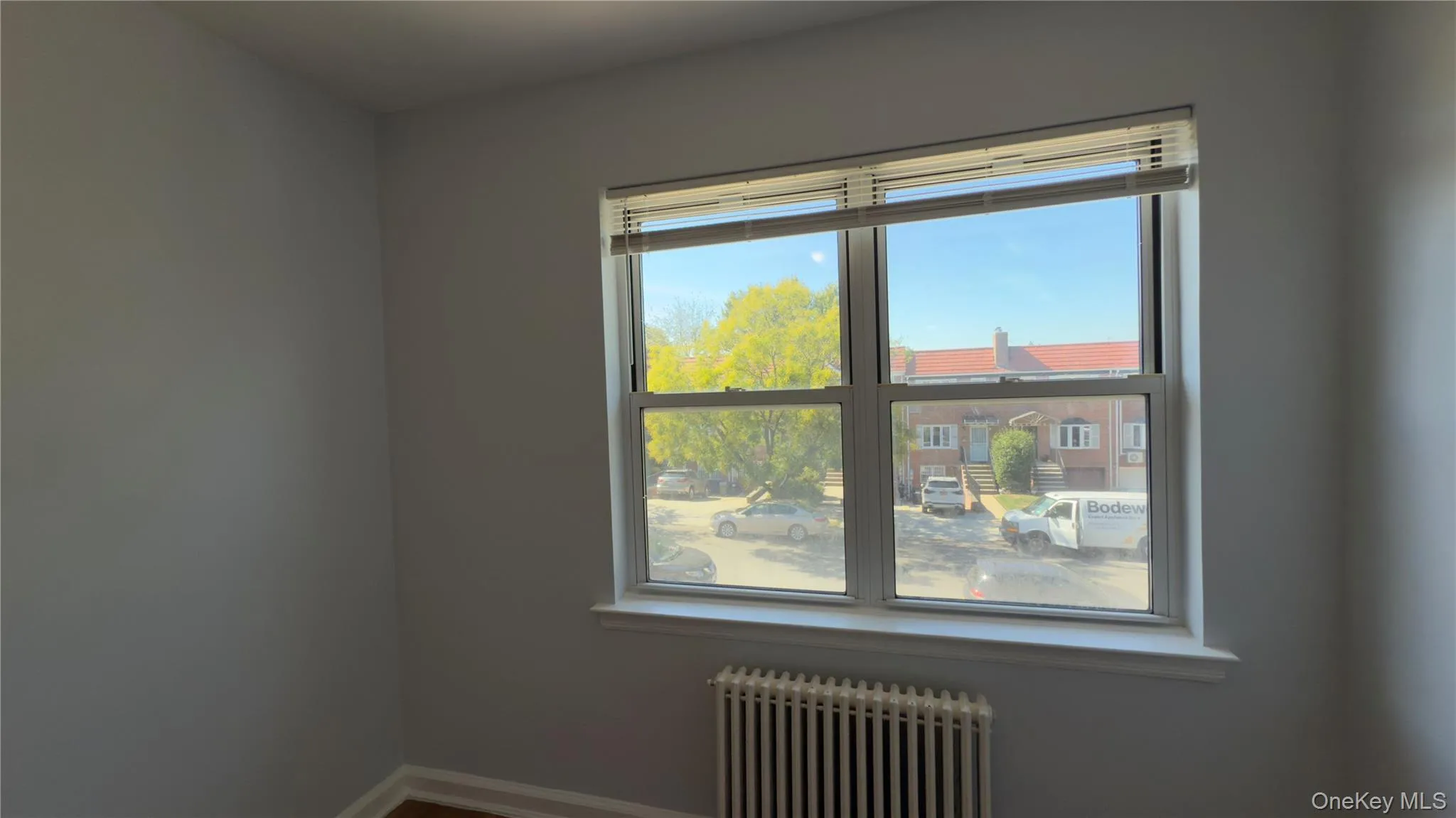 Unfurnished room with radiator and baseboards Unfurnished room with radiator and baseboards