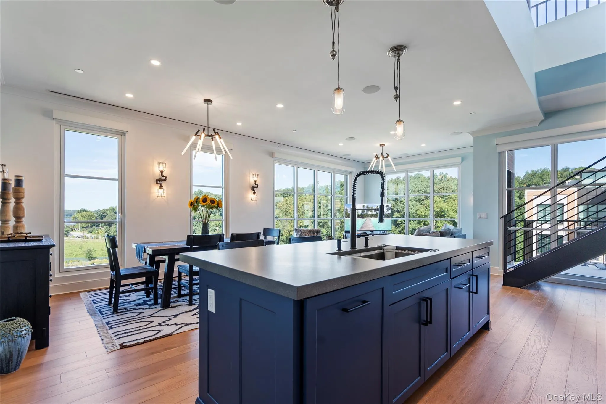 Kitchen with blue cabinets with natural light, a kitchen island with sink, light flooring, and recessed lighting Kitchen with blue cabinets with natural light, a kitchen island with sink, light flooring, and recessed lighting