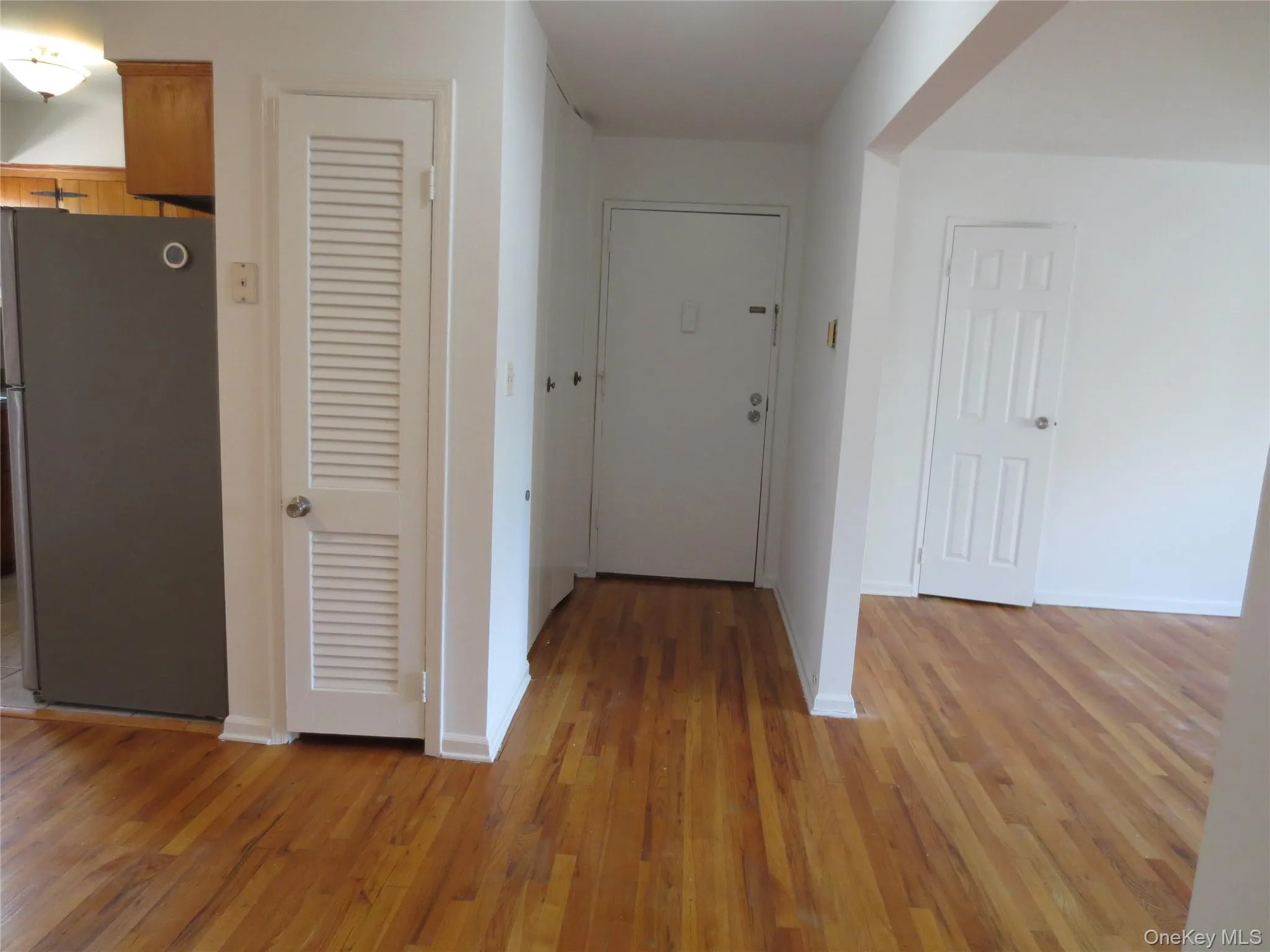 Hallway with baseboards and light wood-style flooring Hallway with baseboards and light wood-style flooring