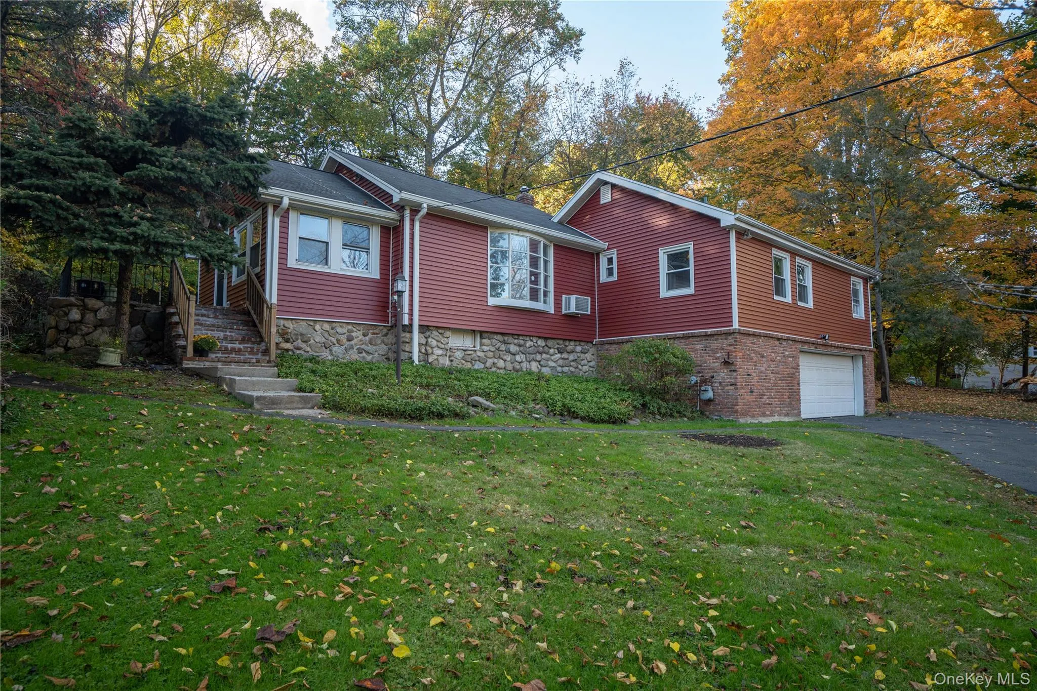 View of home's exterior featuring asphalt driveway, a garage, and a yard View of home's exterior featuring asphalt driveway, a garage, and a yard