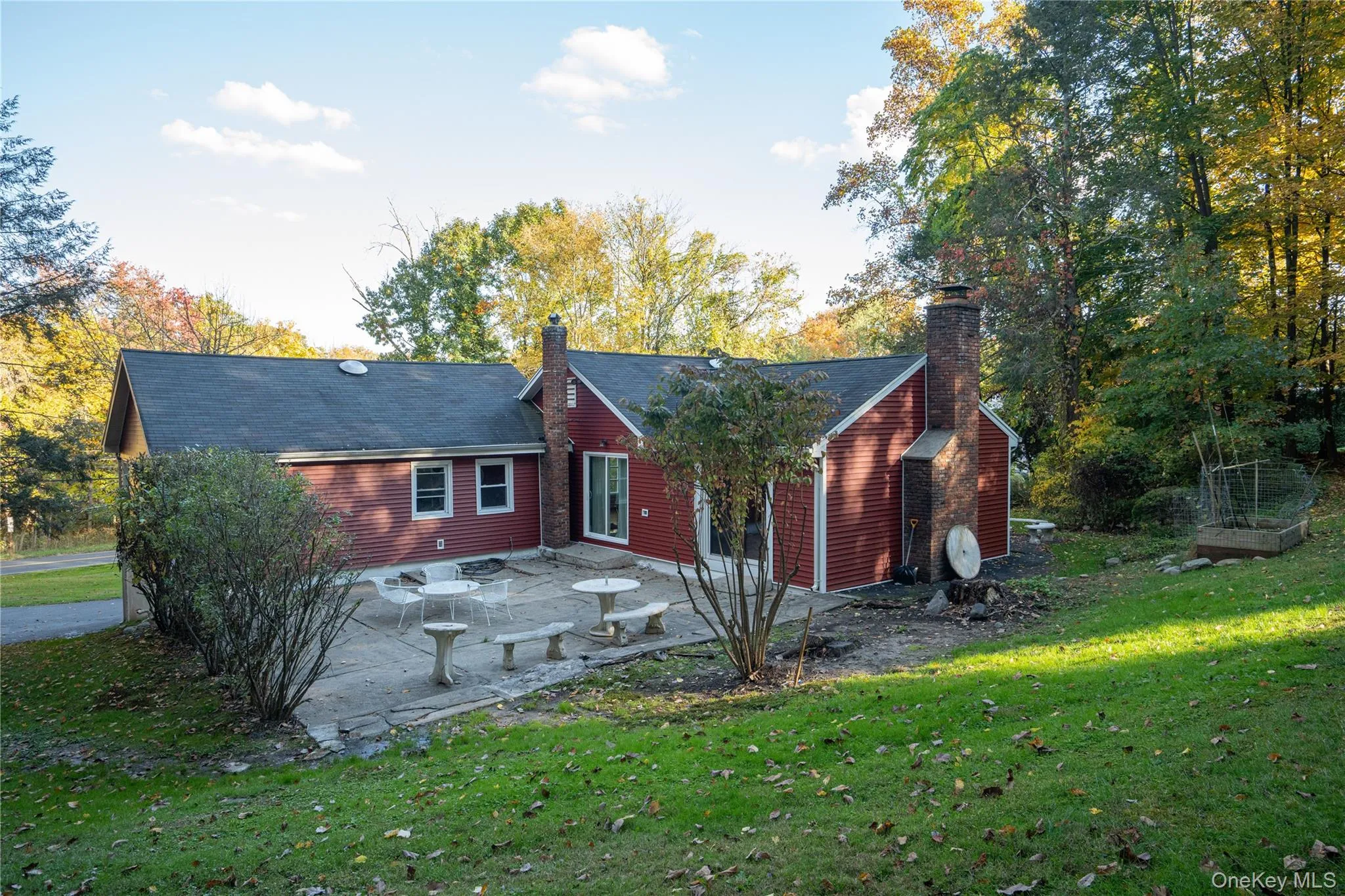 Back of property featuring a lawn, a chimney, and a patio Back of property featuring a lawn, a chimney, and a patio
