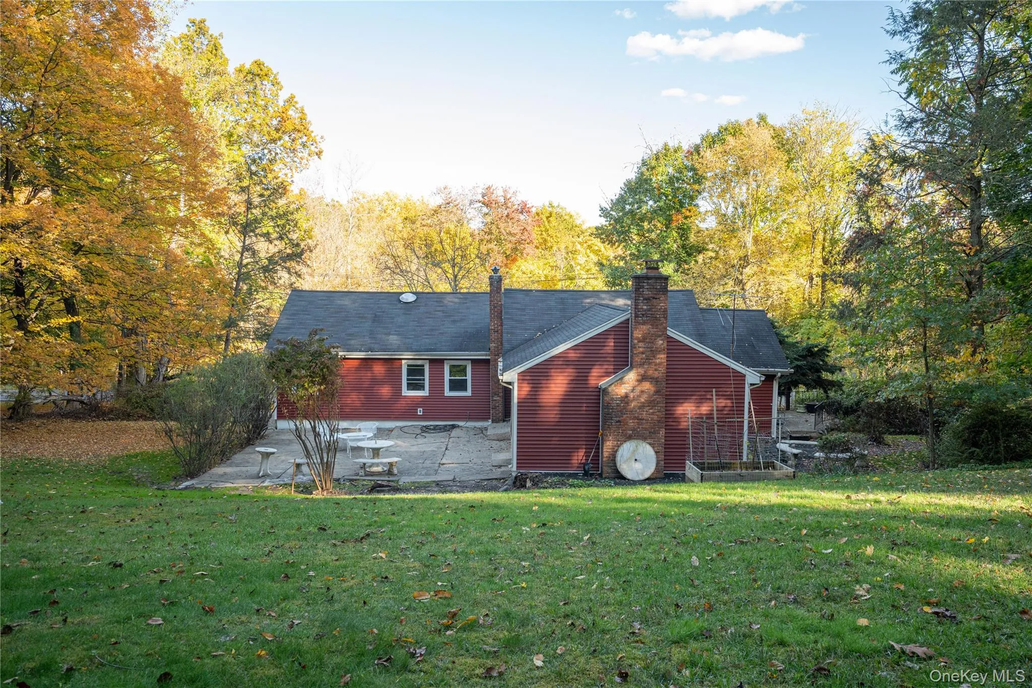 Rear view of property with a patio area, a lawn, and a chimney Rear view of property with a patio area, a lawn, and a chimney