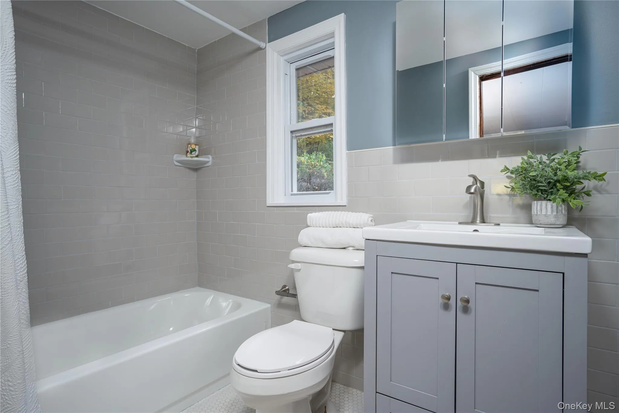 Bathroom with shower / bath combination with curtain, tile walls, and vanity Bathroom with shower / bath combination with curtain, tile walls, and vanity