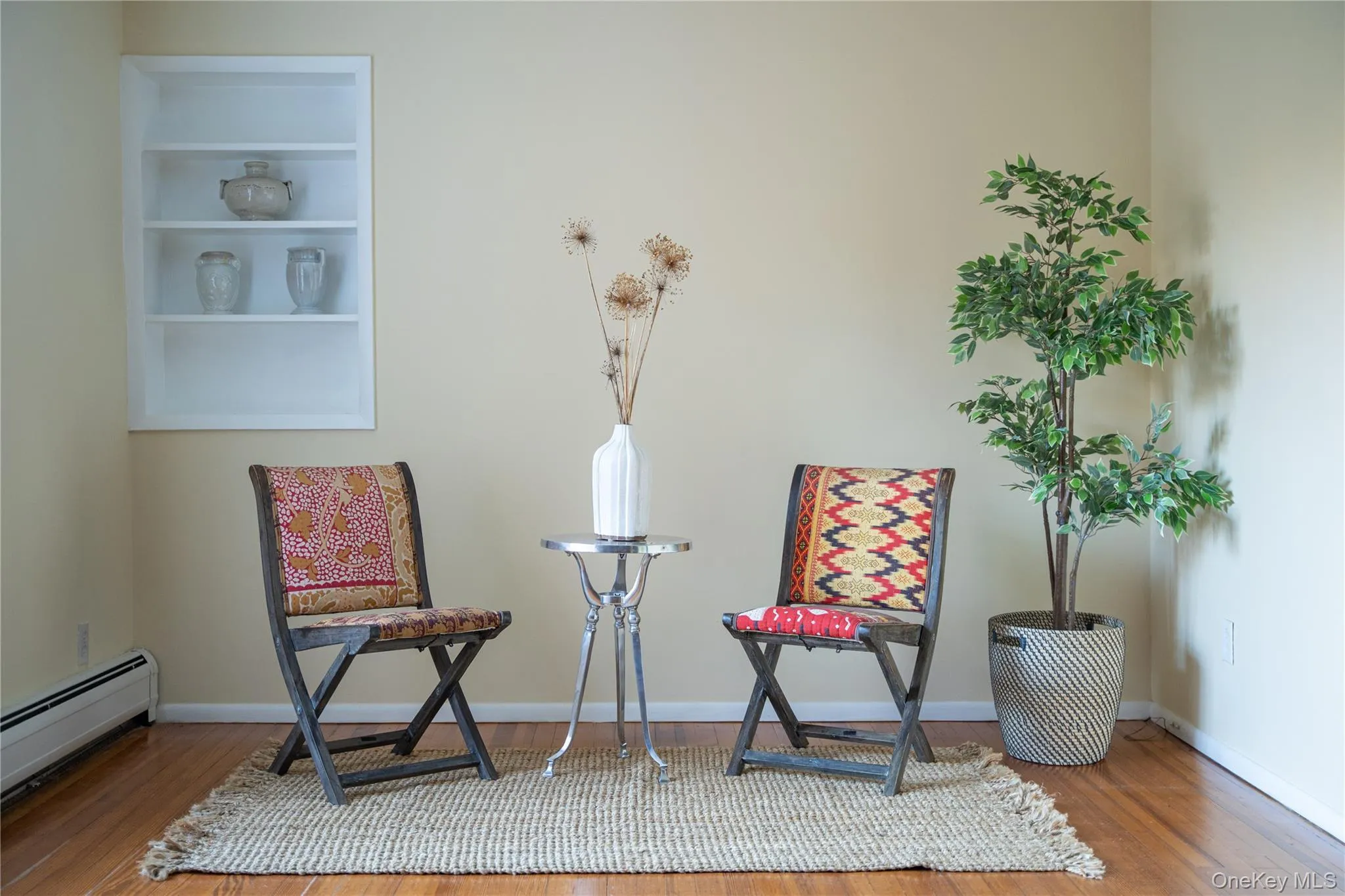 Living area with a baseboard heating unit and wood finished floors Living area with a baseboard heating unit and wood finished floors
