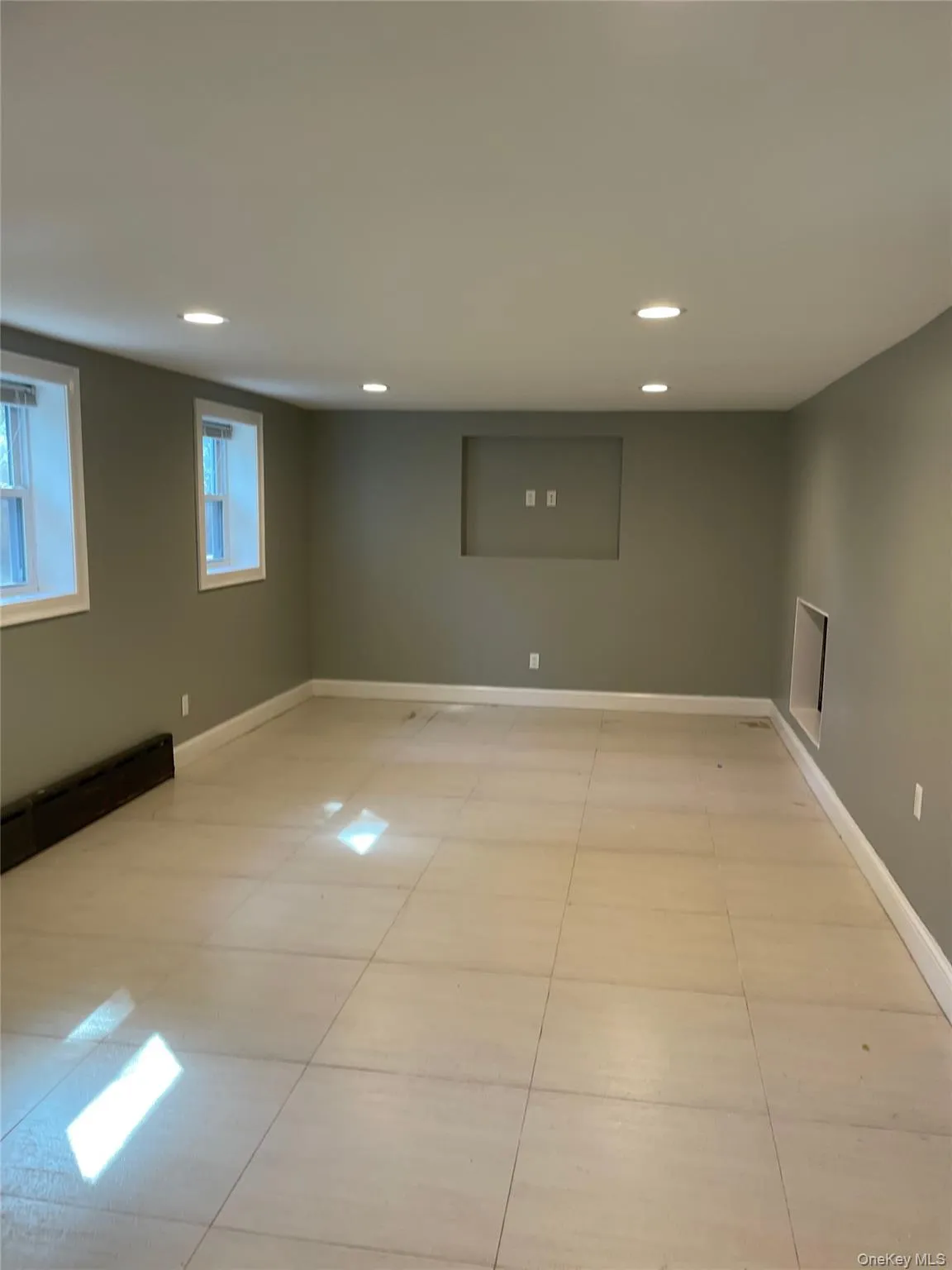 Unfurnished room featuring a baseboard heating unit, recessed lighting, and light tile patterned floors Unfurnished room featuring a baseboard heating unit, recessed lighting, and light tile patterned floors