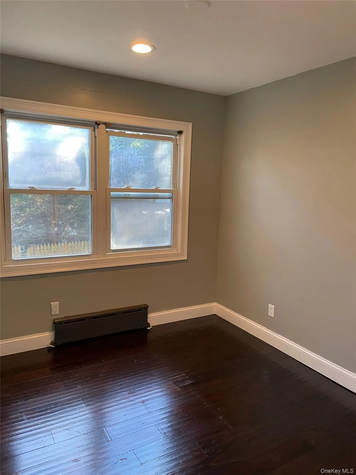 Spare room featuring dark wood finished floors, a baseboard heating unit, and recessed lighting Spare room featuring dark wood finished floors, a baseboard heating unit, and recessed lighting