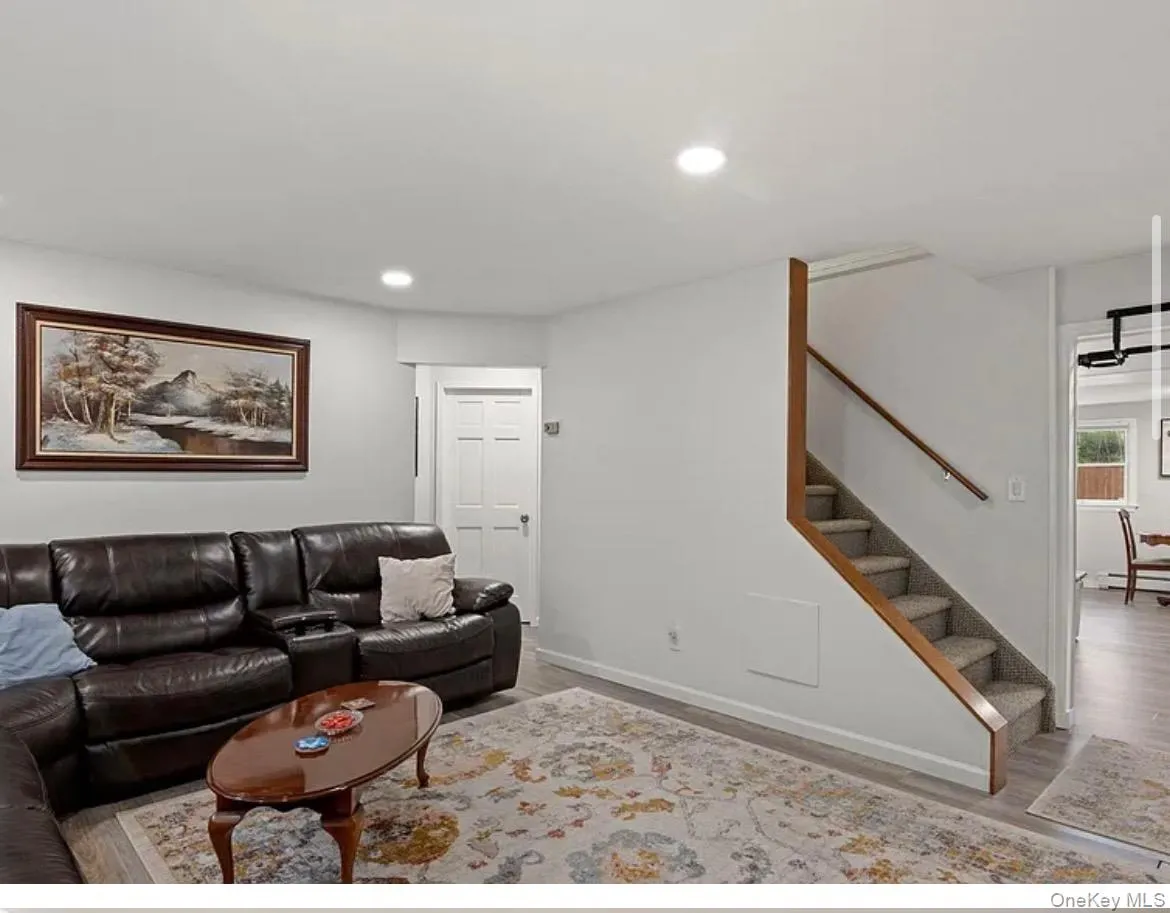 Living area with wood finished floors, recessed lighting, and stairway Living area with wood finished floors, recessed lighting, and stairway