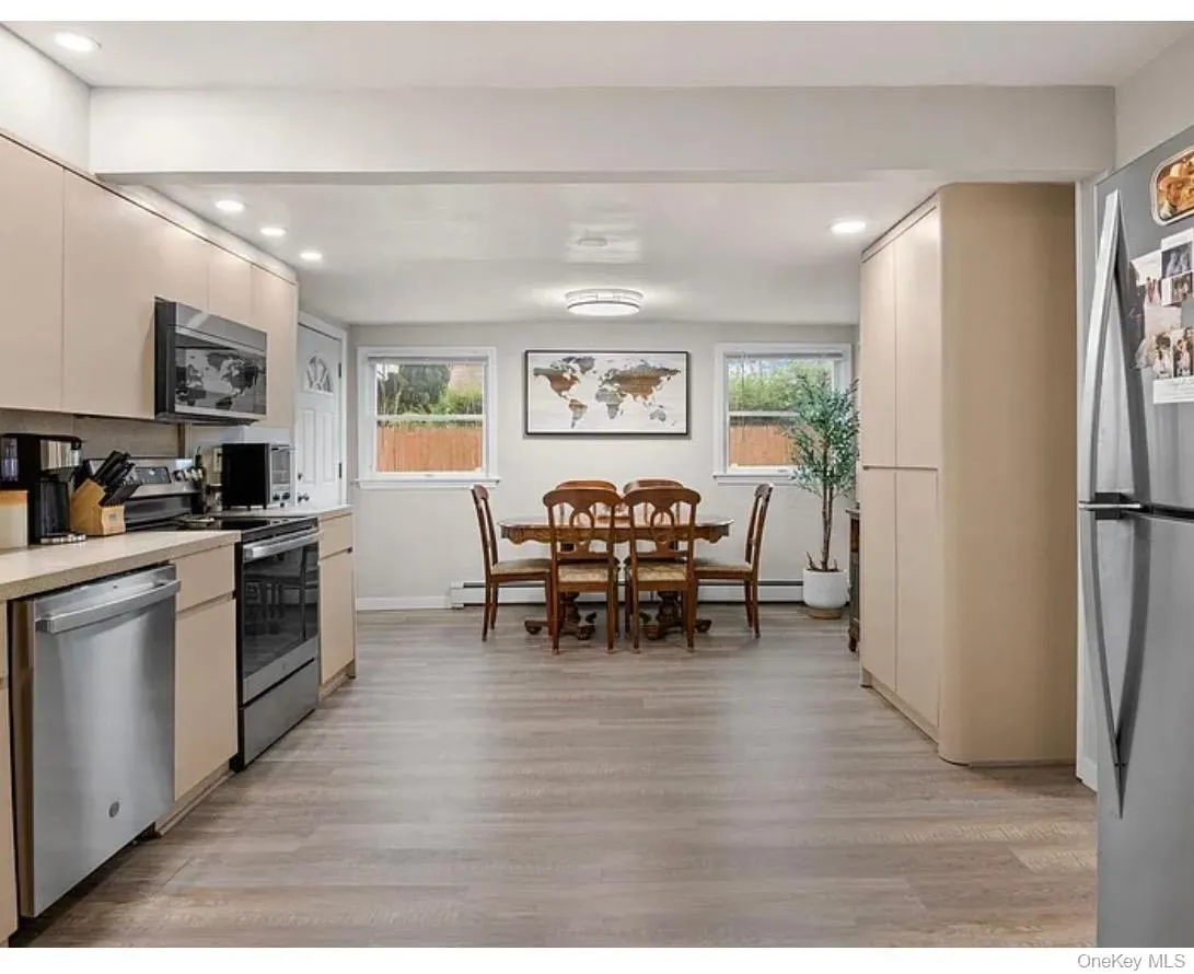 Kitchen featuring stainless steel appliances, light countertops, light wood-style flooring, recessed lighting, and baseboard heating Kitchen featuring stainless steel appliances, light countertops, light wood-style flooring, recessed lighting, and baseboard heating