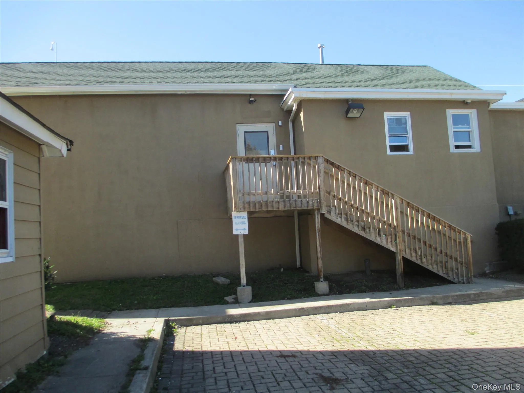 Back of property featuring roof with shingles, stucco siding, a deck, and stairs Back of property featuring roof with shingles, stucco siding, a deck, and stairs