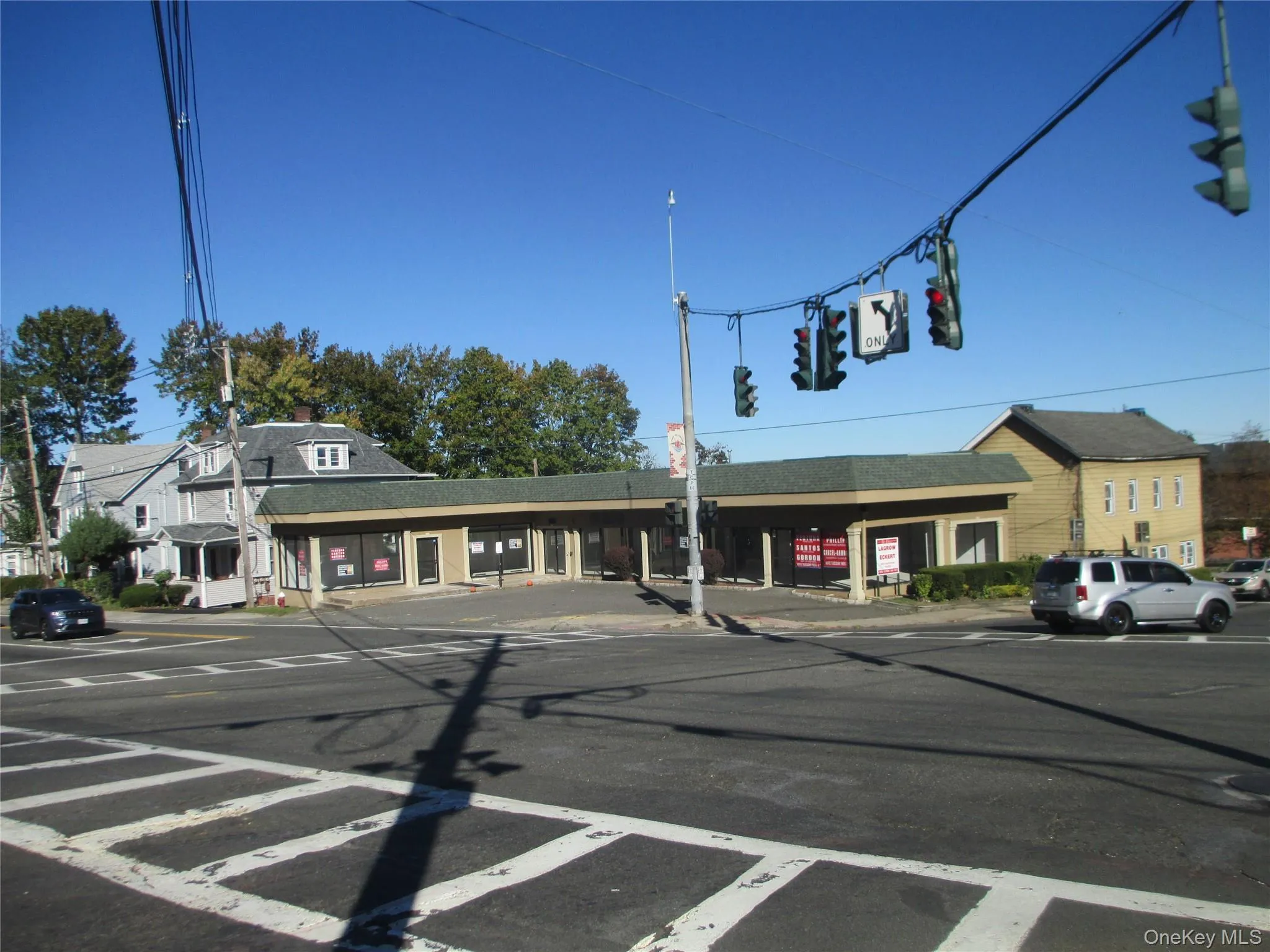 View of asphalt road with curbs, sidewalks, and traffic lights View of asphalt road with curbs, sidewalks, and traffic lights