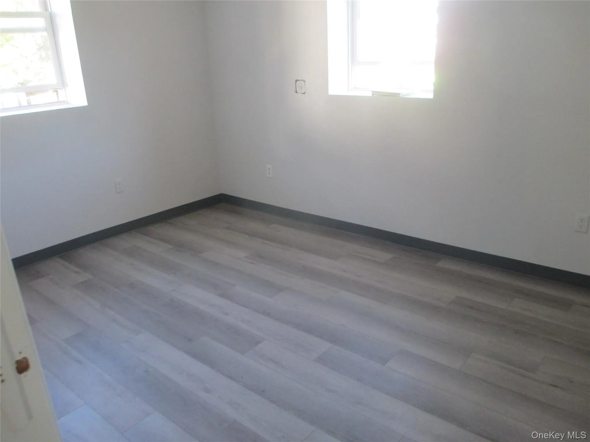 Spare room featuring baseboards and light wood-style floors Spare room featuring baseboards and light wood-style floors