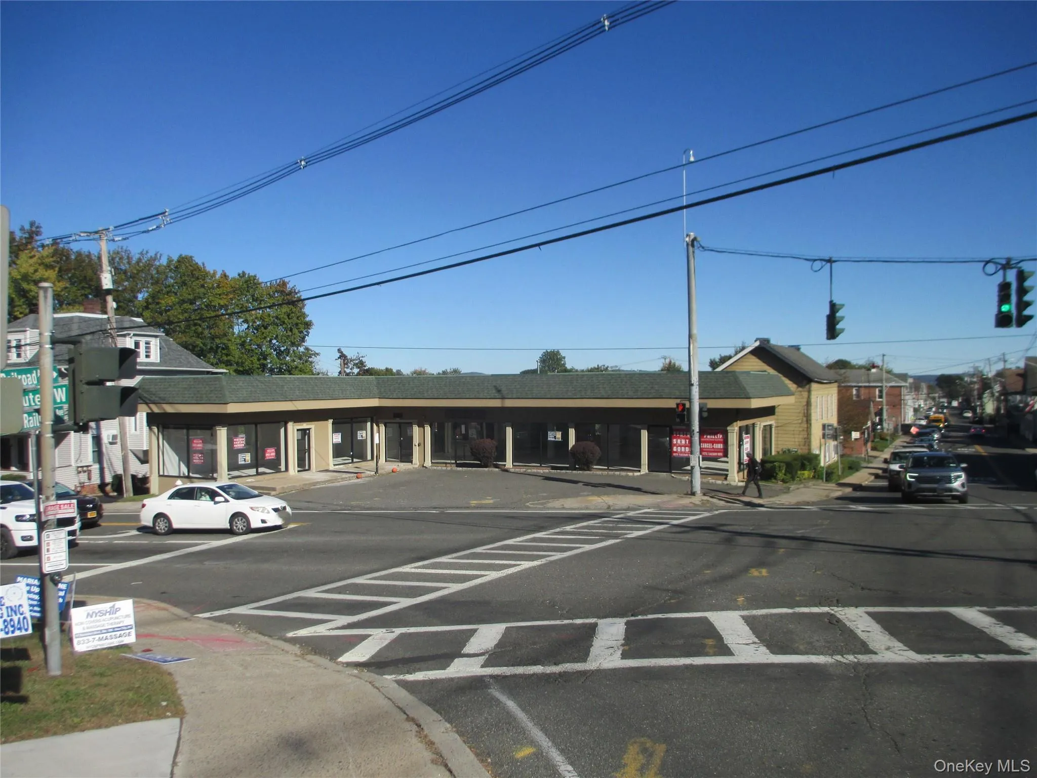 View of asphalt road featuring sidewalks, curbs, traffic lights, and street lighting View of asphalt road featuring sidewalks, curbs, traffic lights, and street lighting