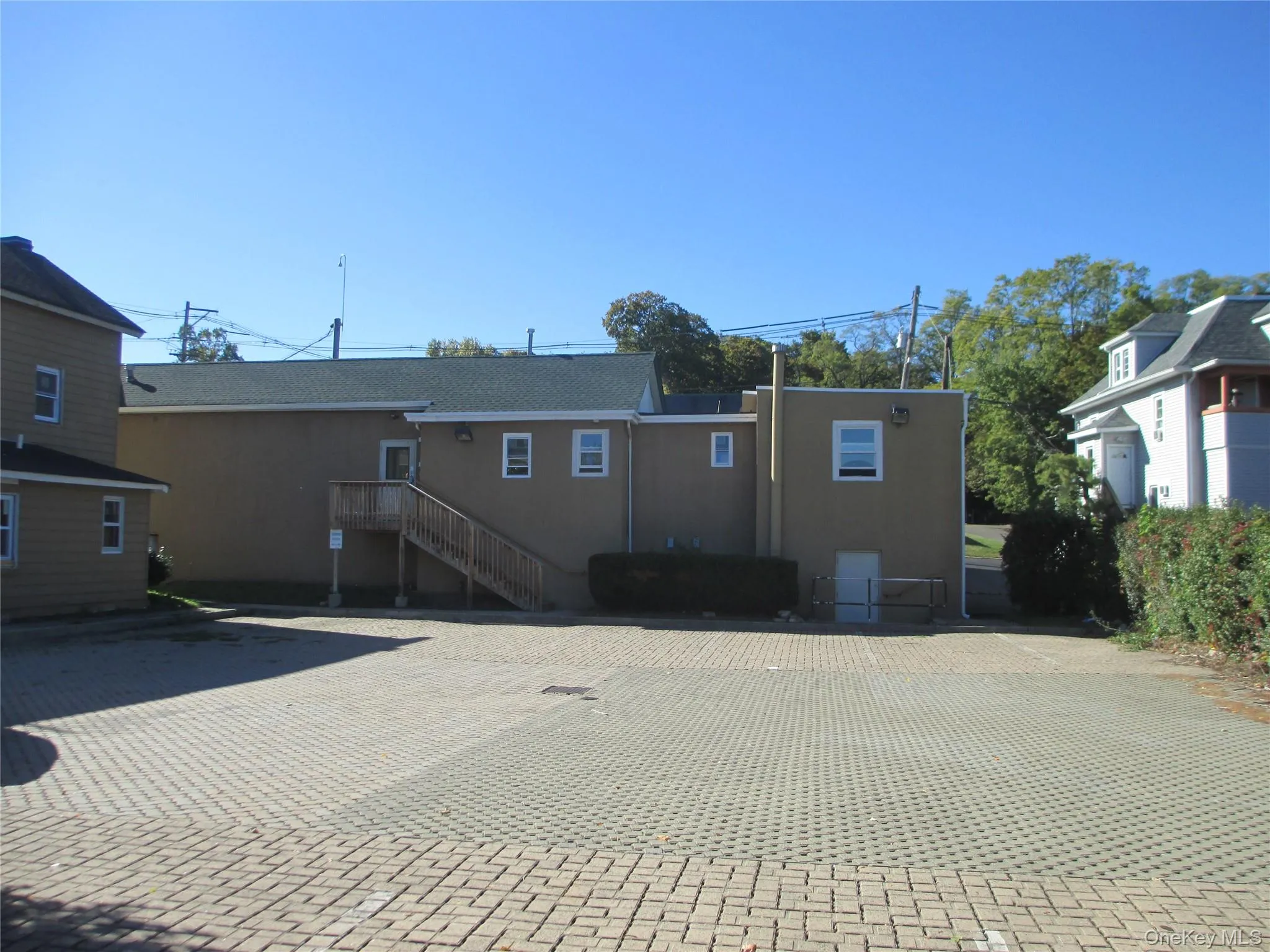 Back of property with stucco siding, a patio area, and stairs Back of property with stucco siding, a patio area, and stairs
