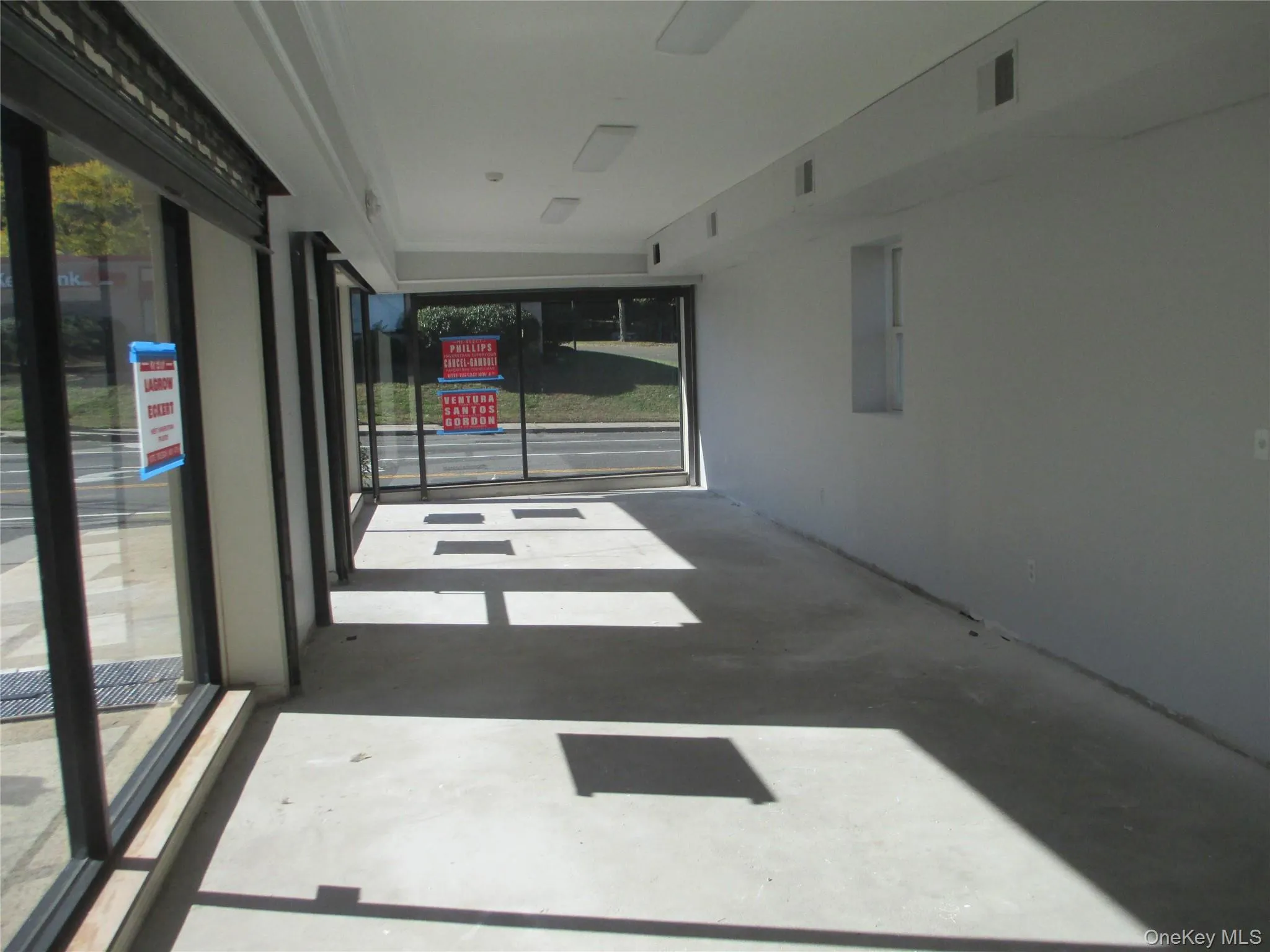 Unfurnished room featuring unfinished concrete floors and plenty of natural light Unfurnished room featuring unfinished concrete floors and plenty of natural light