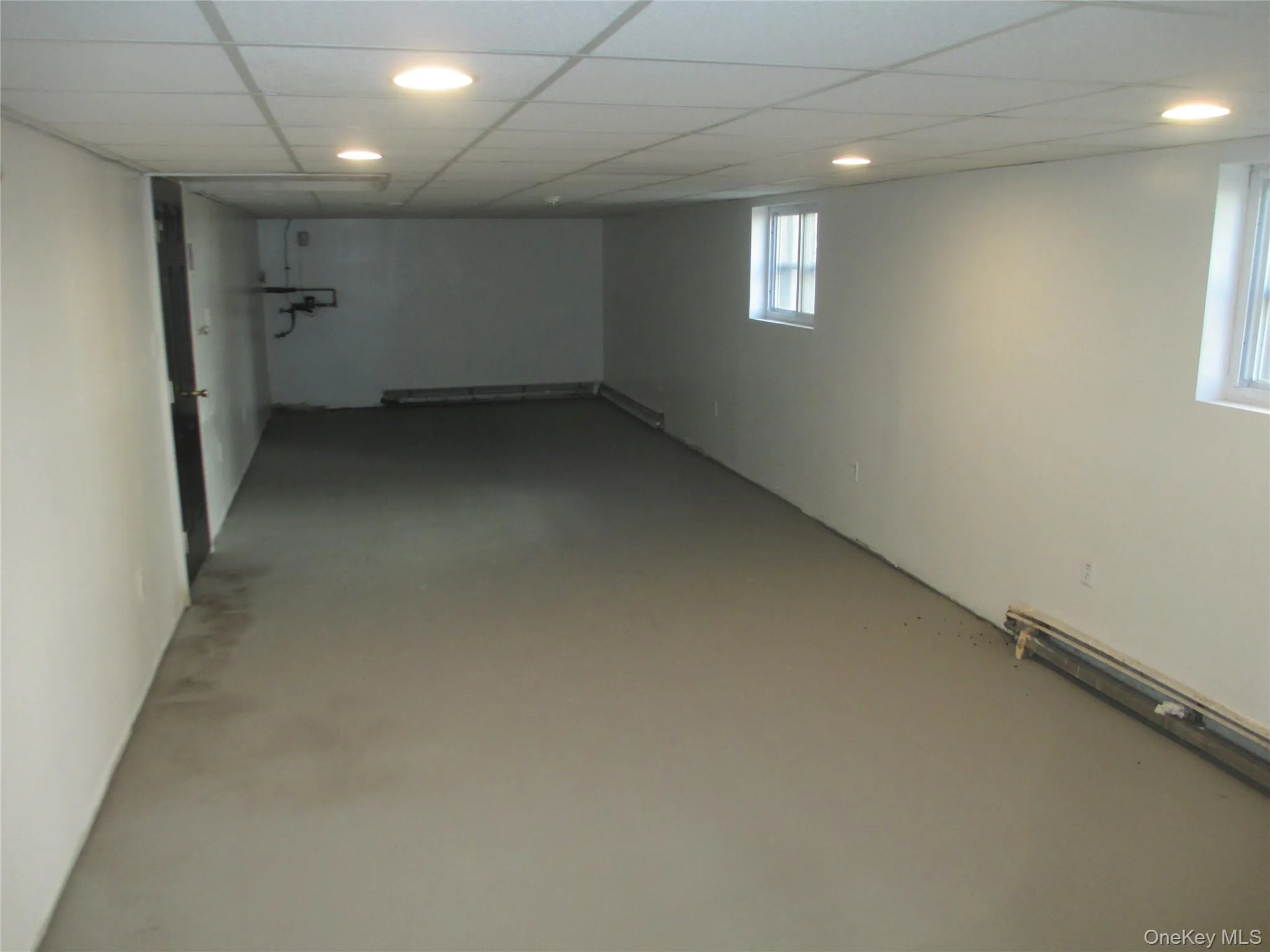 Below grade area featuring a drop ceiling and recessed lighting Below grade area featuring a drop ceiling and recessed lighting