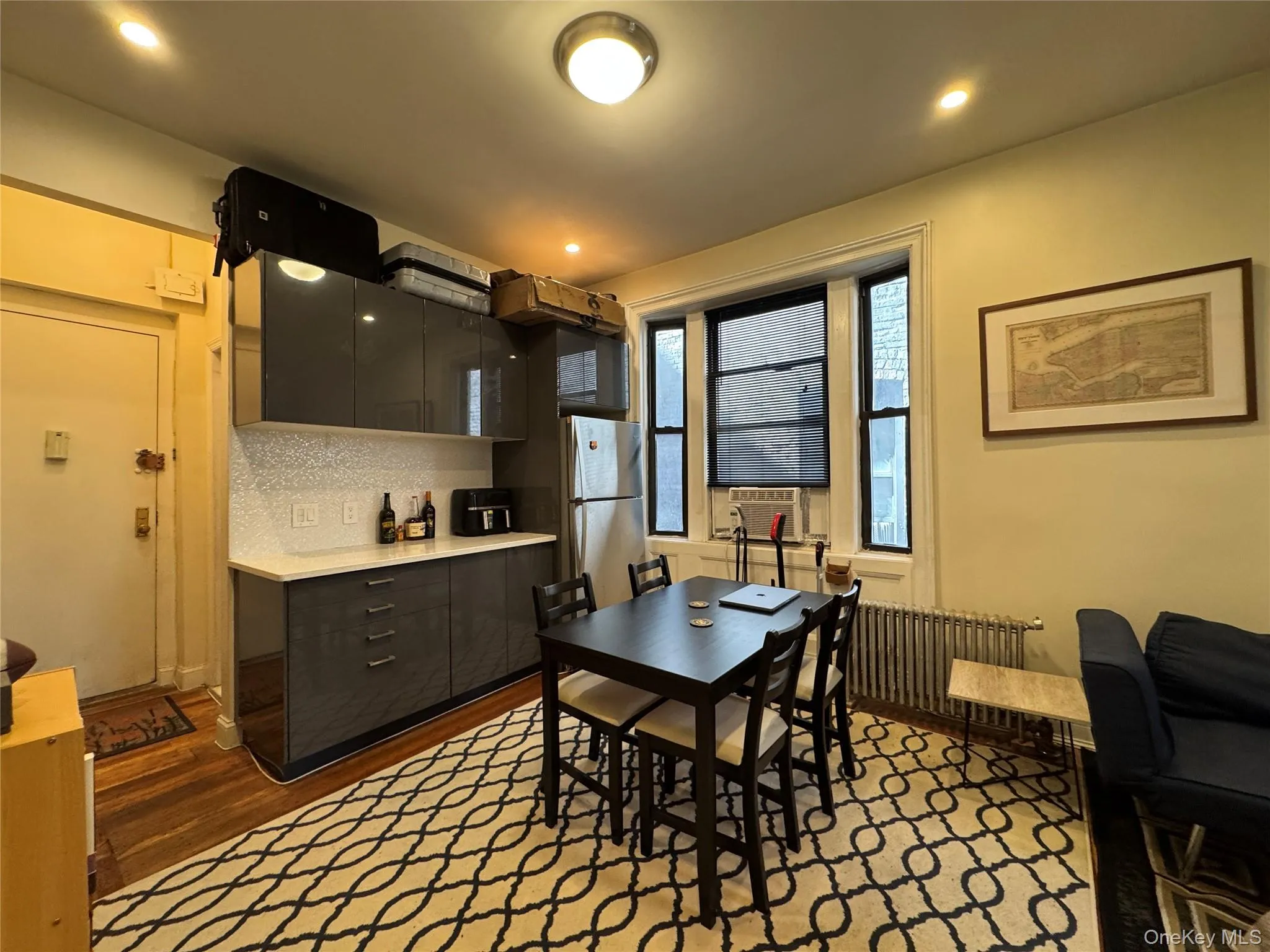 Dining space featuring radiator heating unit, dark wood-style flooring, recessed lighting, and cooling unit Dining space featuring radiator heating unit, dark wood-style flooring, recessed lighting, and cooling unit