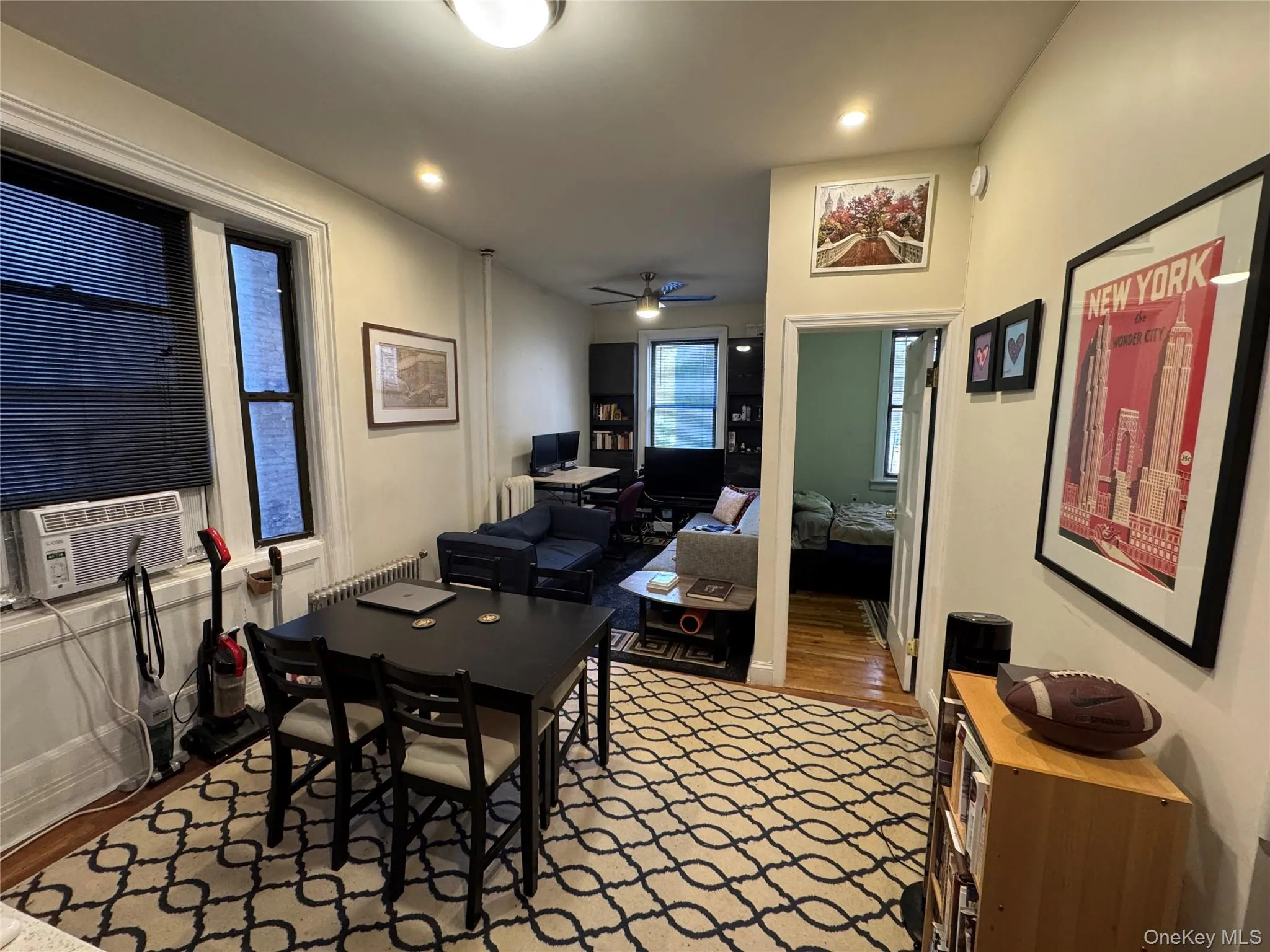 Home office with wood finished floors, ceiling fan, radiator heating unit, cooling unit, and recessed lighting Home office with wood finished floors, ceiling fan, radiator heating unit, cooling unit, and recessed lighting