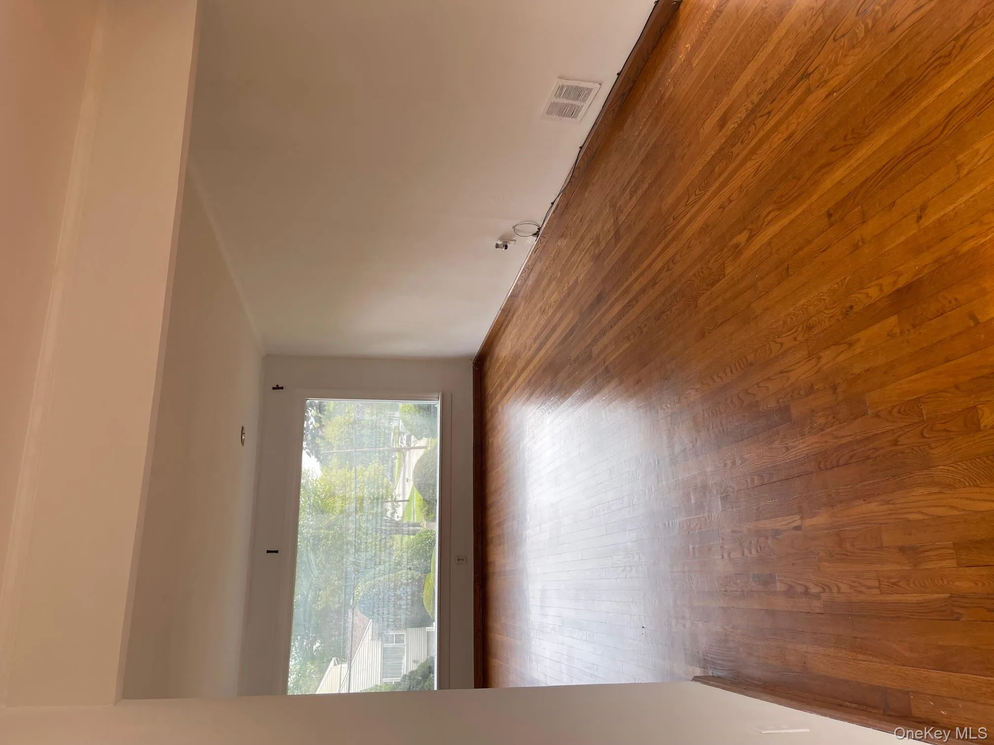Unfurnished room with wood-type flooring and baseboards Unfurnished room with wood-type flooring and baseboards