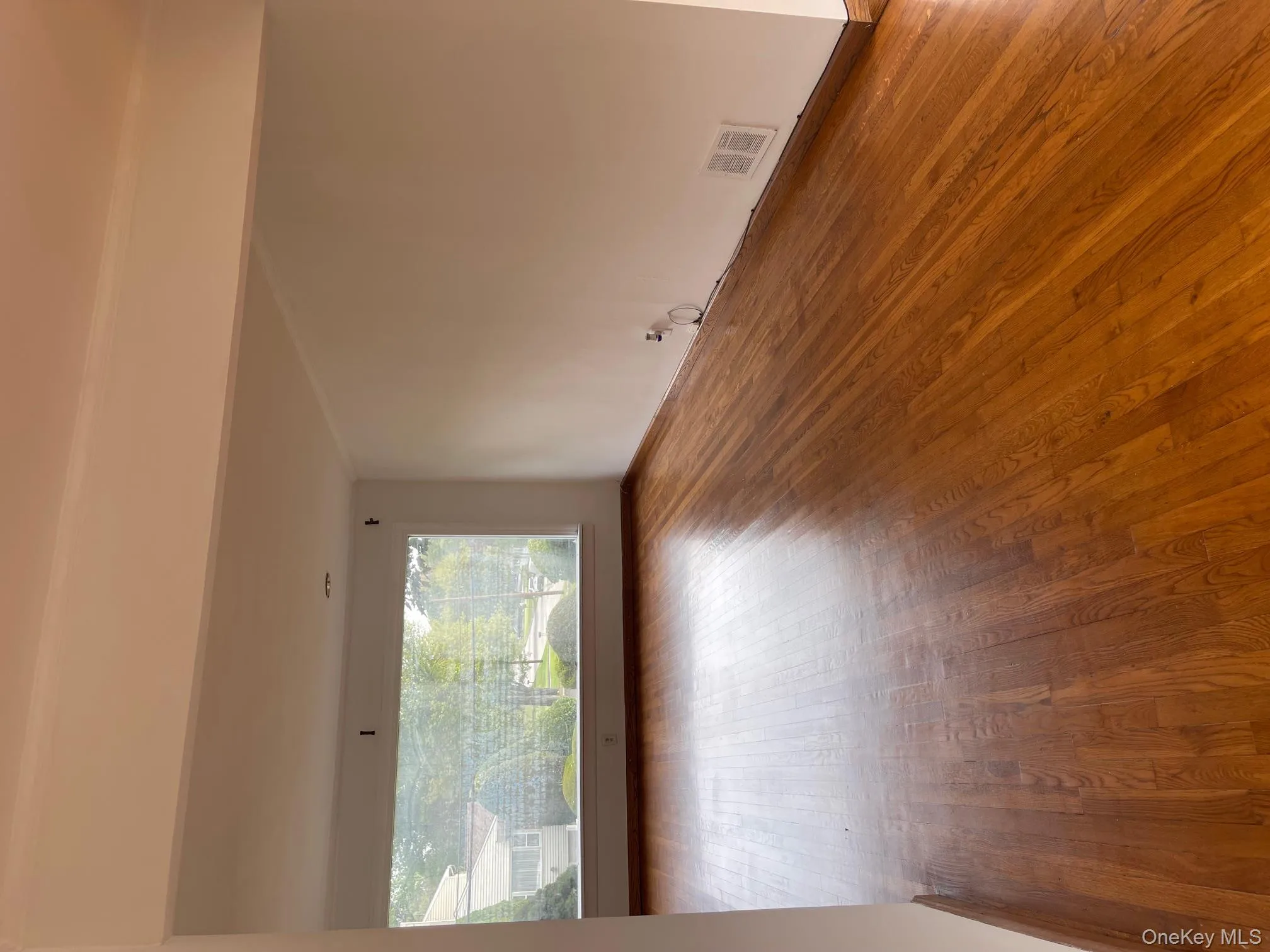 Spare room with hardwood / wood-style floors and baseboards Spare room with hardwood / wood-style floors and baseboards