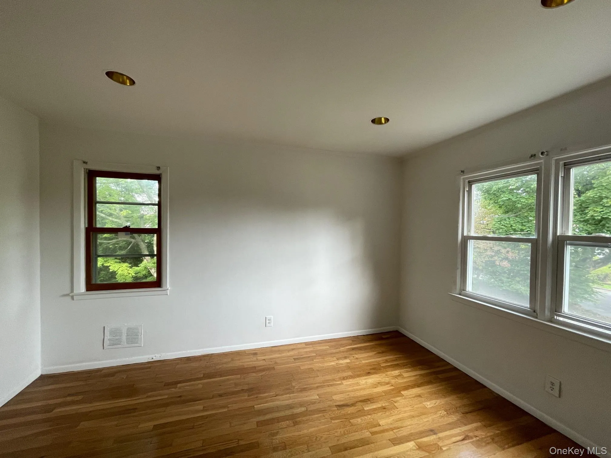 Spare room with plenty of natural light, light wood finished floors, and recessed lighting Spare room with plenty of natural light, light wood finished floors, and recessed lighting