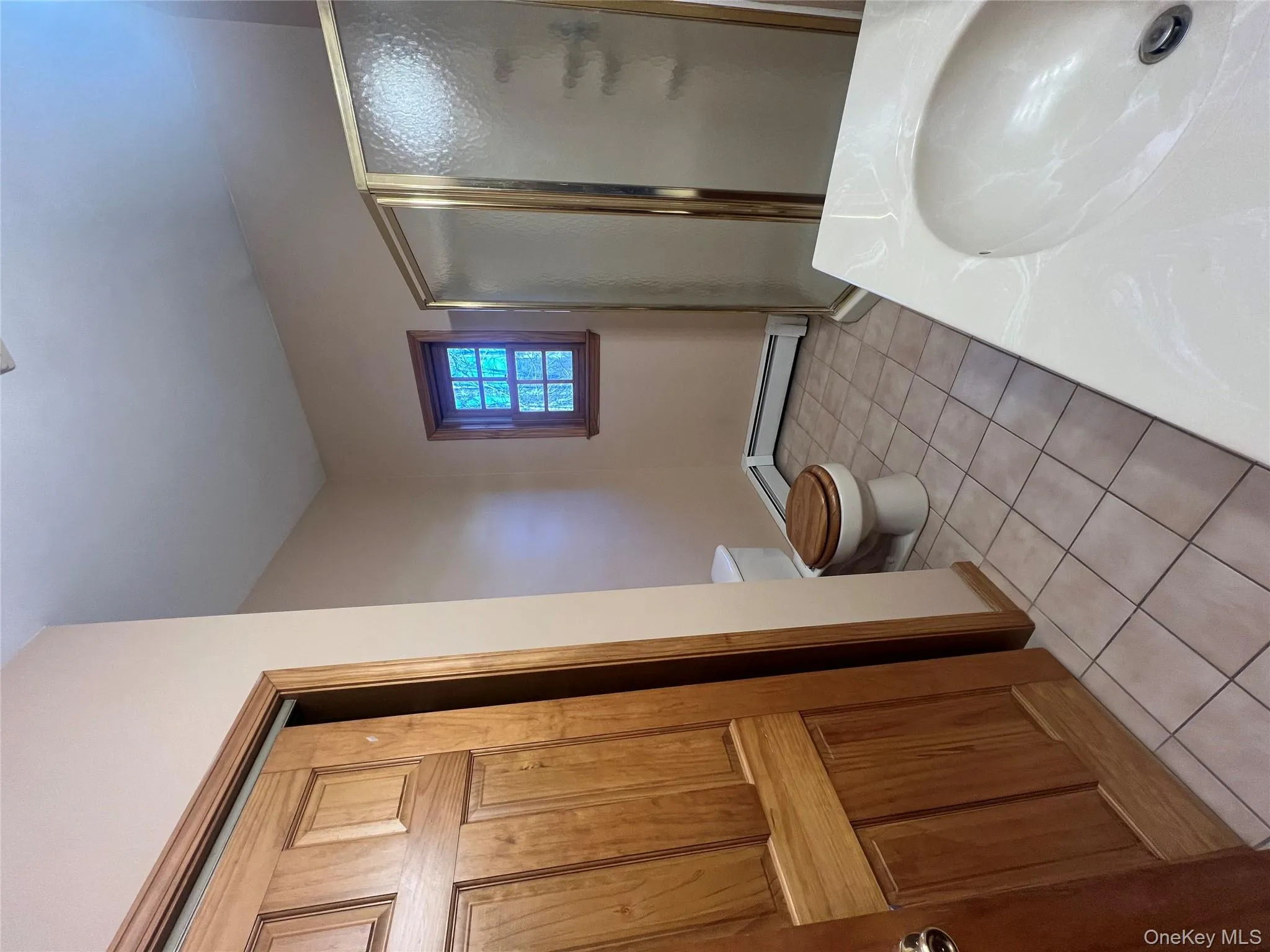Bathroom featuring light tile patterned floors, a shower stall, a baseboard radiator, and vanity Bathroom featuring light tile patterned floors, a shower stall, a baseboard radiator, and vanity