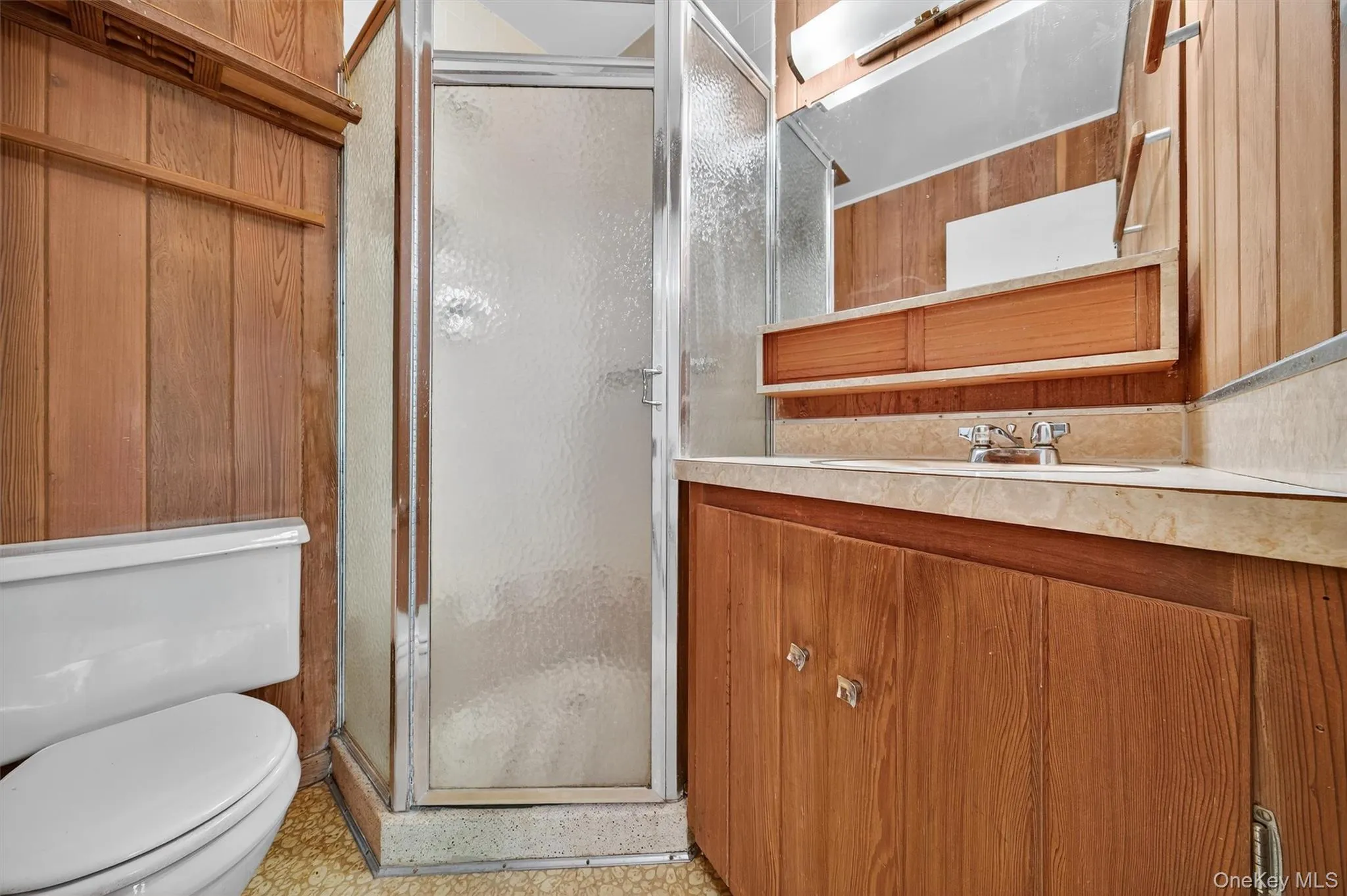 Full bathroom featuring a stall shower, vanity, and wood walls Full bathroom featuring a stall shower, vanity, and wood walls