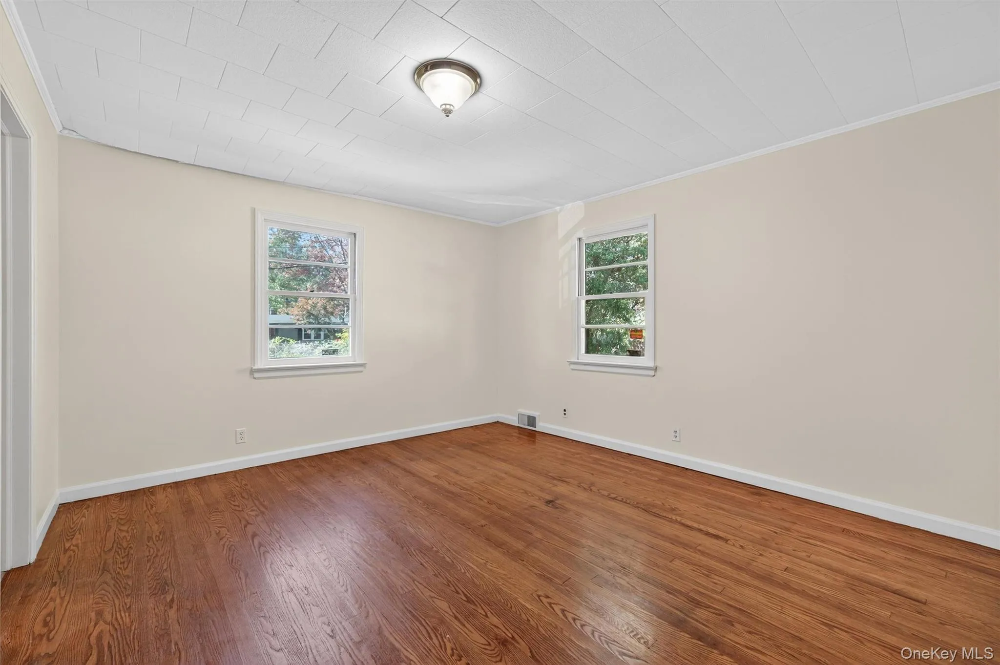Unfurnished room with wood finished floors and crown molding Unfurnished room with wood finished floors and crown molding