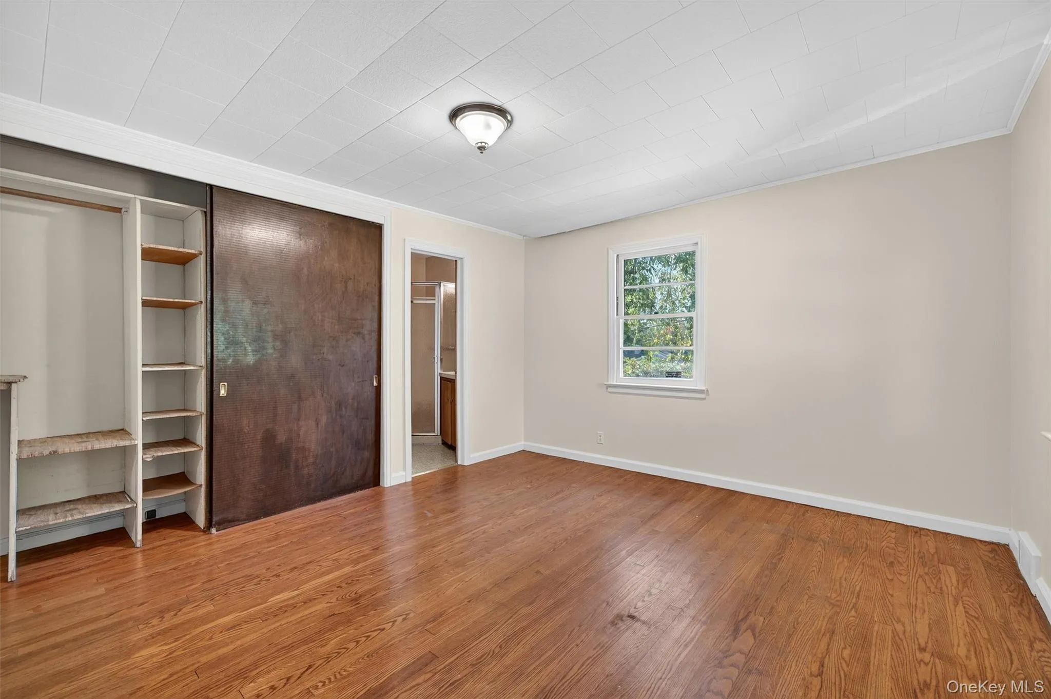 Unfurnished bedroom with a closet and light wood-style floors Unfurnished bedroom with a closet and light wood-style floors