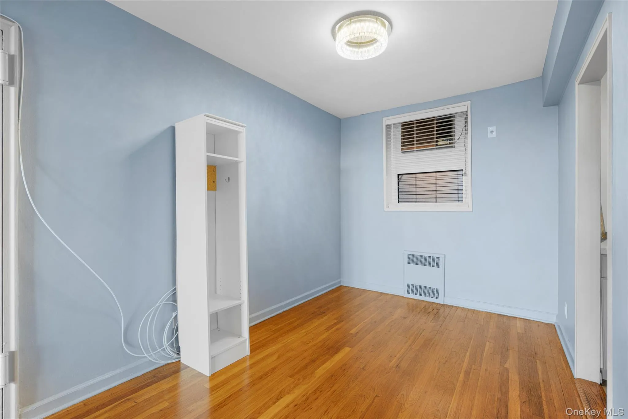 Spare room featuring light wood-style floors and baseboards Spare room featuring light wood-style floors and baseboards