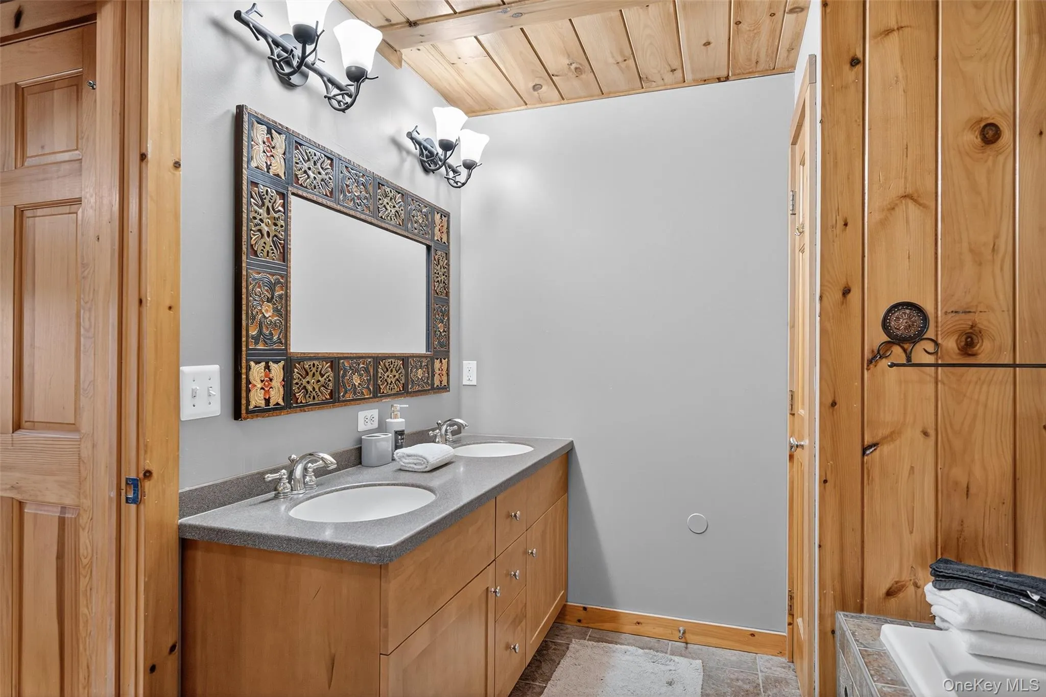 Full bath with double vanity, wood ceiling, and a relaxing tiled tub Full bath with double vanity, wood ceiling, and a relaxing tiled tub