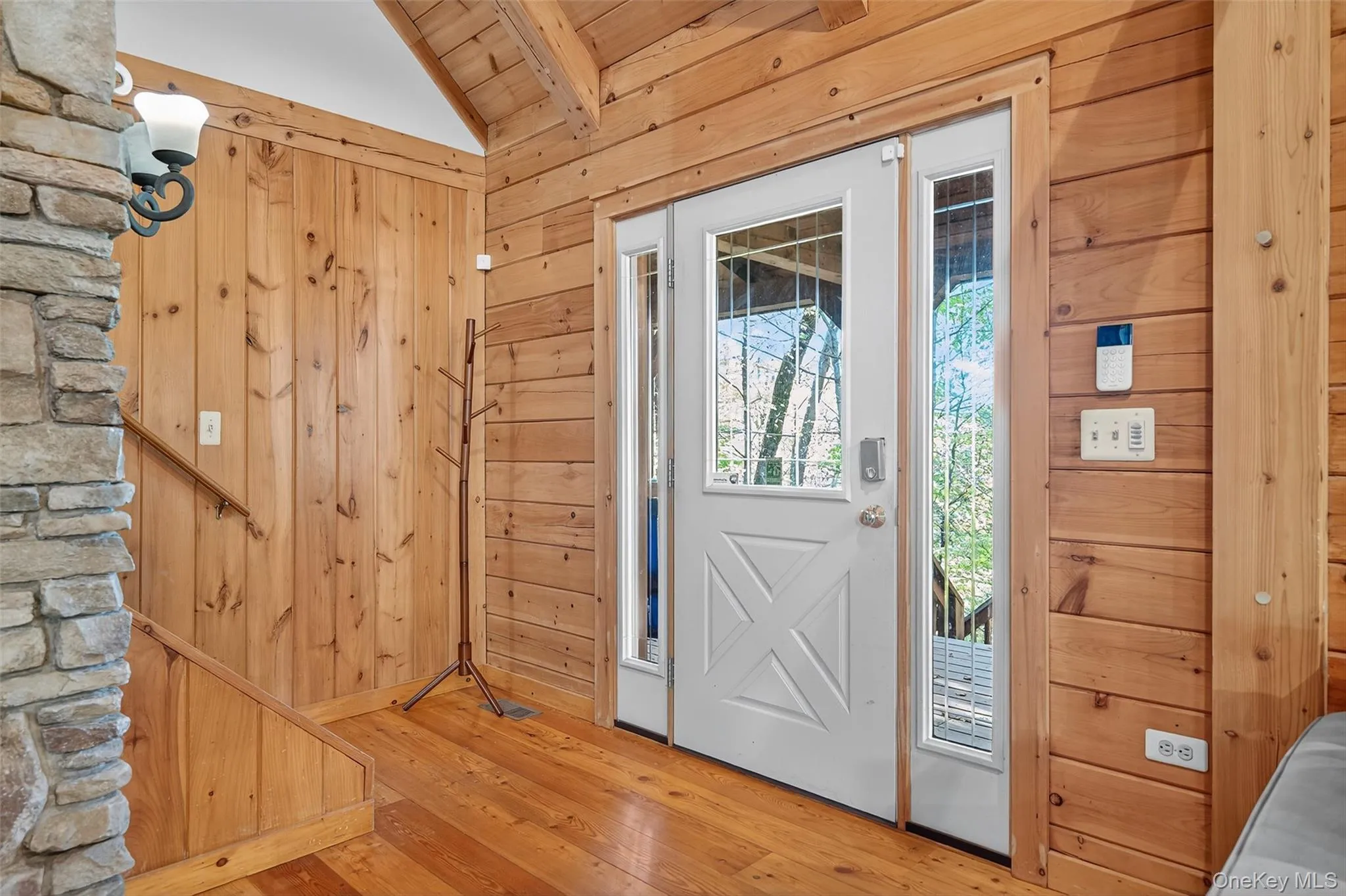 Doorway to outside featuring hardwood / wood-style floors, wood walls, and wooden ceiling Doorway to outside featuring hardwood / wood-style floors, wood walls, and wooden ceiling