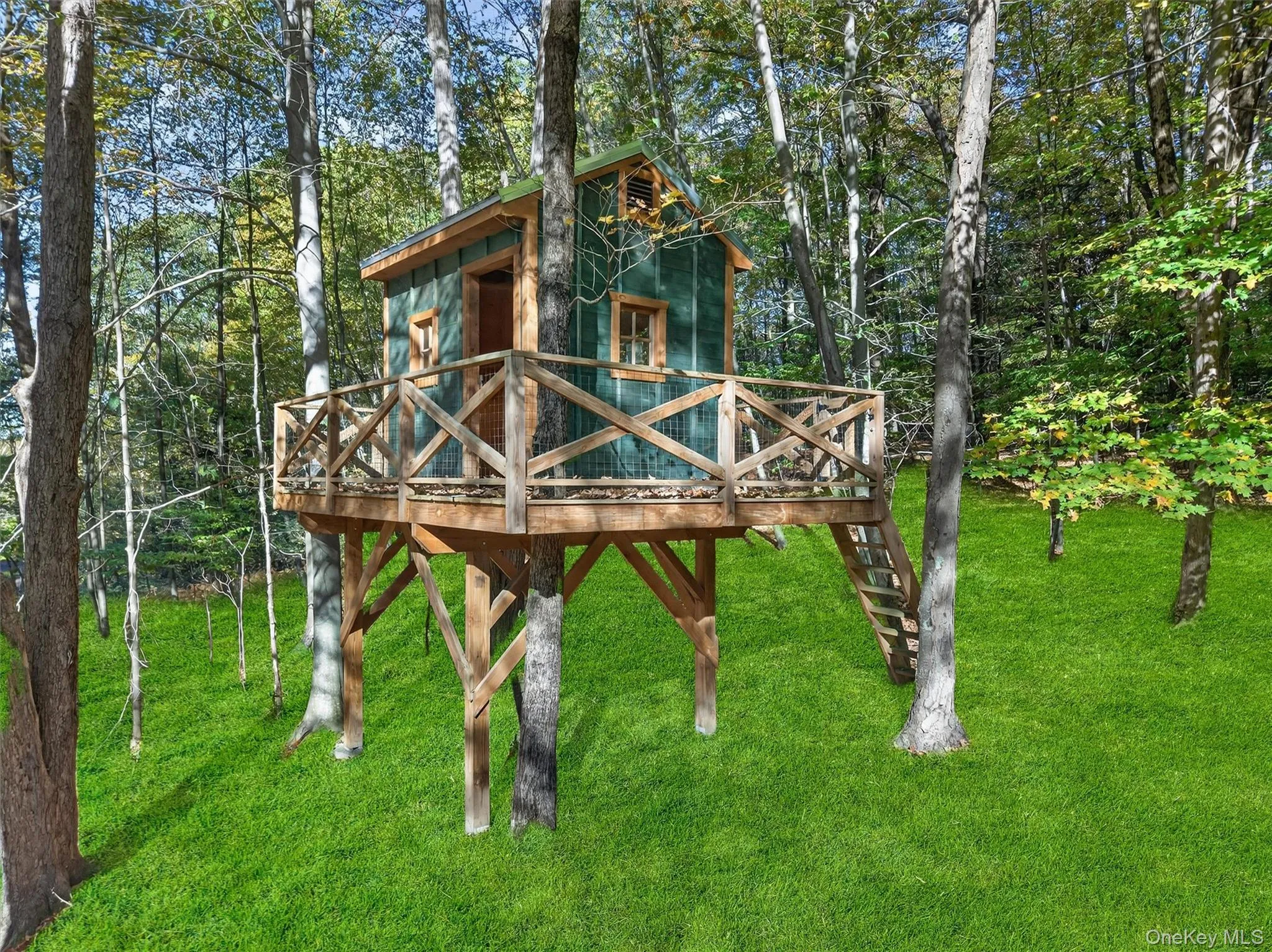 View of playground with a wooden deck, a lawn, and view of scattered trees View of playground with a wooden deck, a lawn, and view of scattered trees