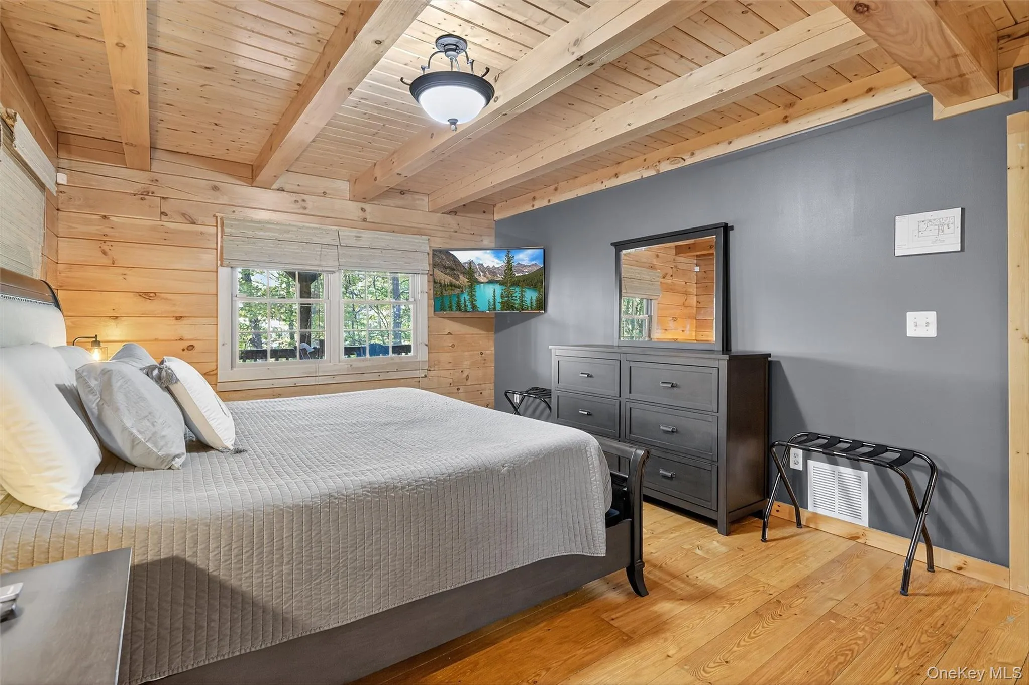 Bedroom featuring wood walls, light wood finished floors, and a wood ceiling with exposed beams Bedroom featuring wood walls, light wood finished floors, and a wood ceiling with exposed beams