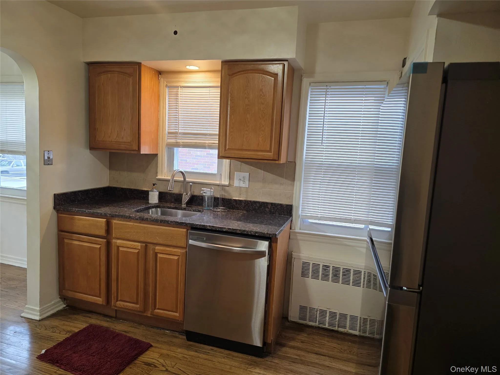 Kitchen with appliances with stainless steel finishes, dark stone countertops, plenty of natural light, and dishwasher included Kitchen with appliances with stainless steel finishes, dark stone countertops, plenty of natural light, and dishwasher included