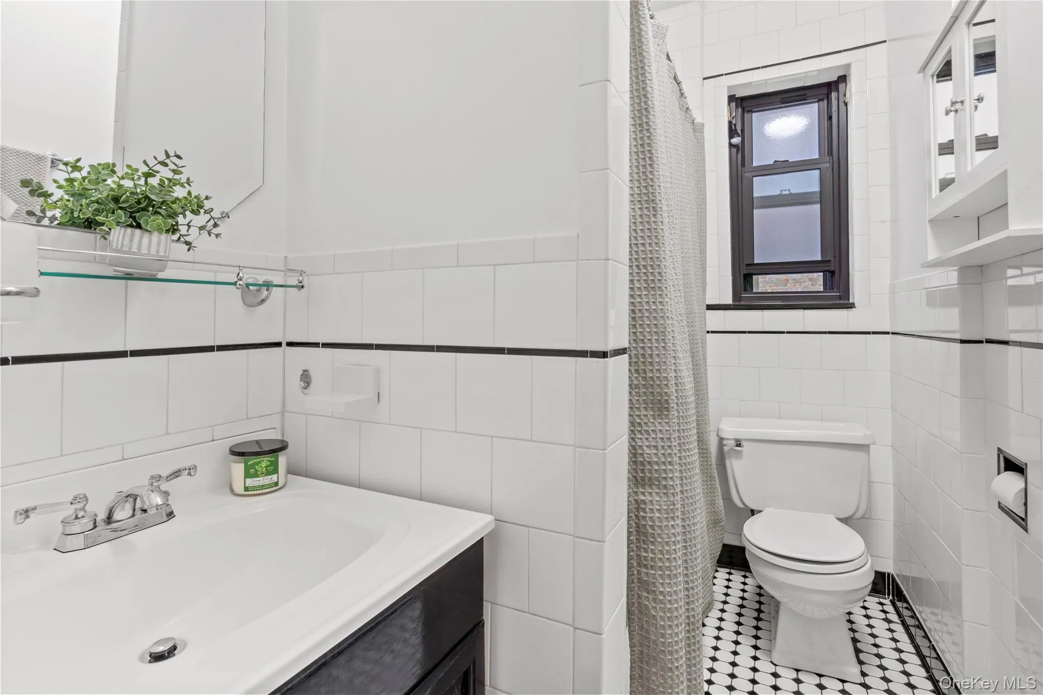 Full bath featuring vanity, tile walls, a shower with shower curtain, and tile patterned flooring Full bath featuring vanity, tile walls, a shower with shower curtain, and tile patterned flooring