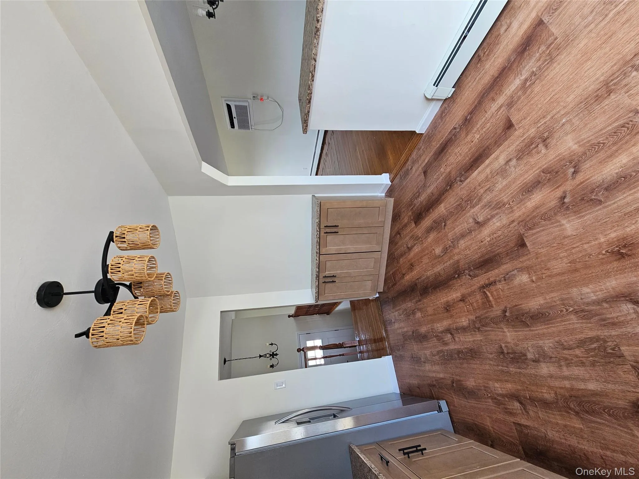 Unfurnished dining area featuring a chandelier, baseboard heating, dark wood-style floors, and a wall unit AC Unfurnished dining area featuring a chandelier, baseboard heating, dark wood-style floors, and a wall unit AC