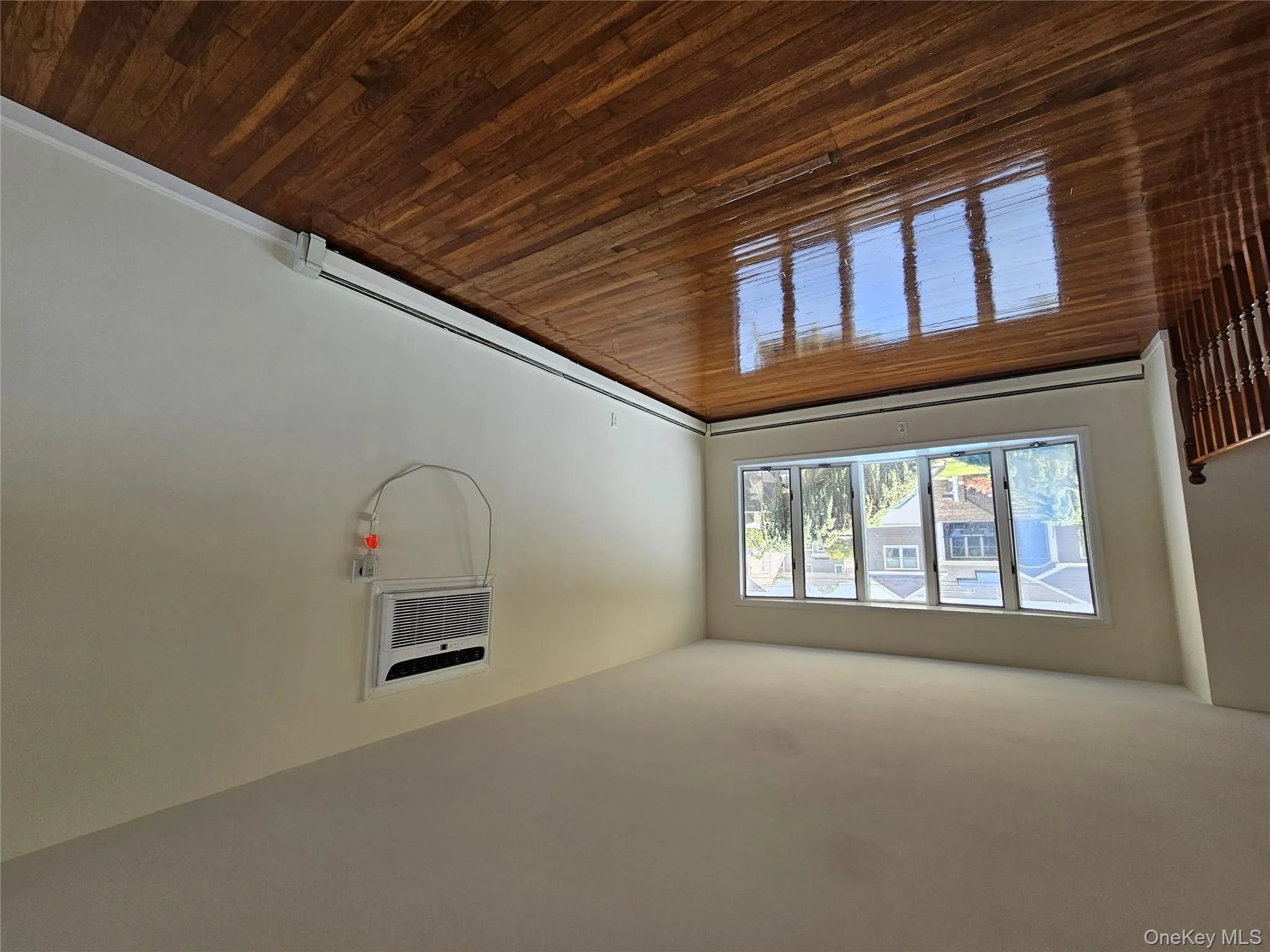 Unfurnished room with dark wood-style floors, a baseboard heating unit, and an AC wall unit Unfurnished room with dark wood-style floors, a baseboard heating unit, and an AC wall unit