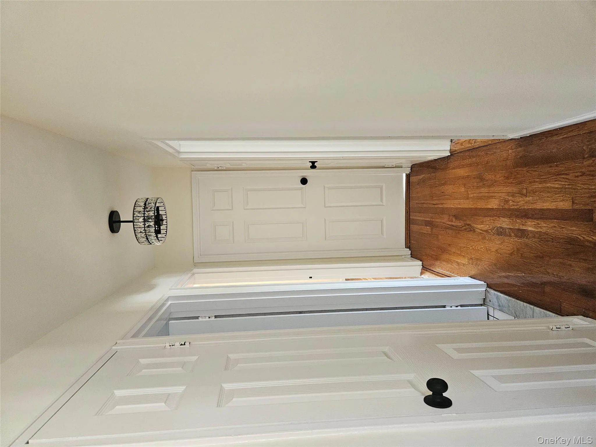 Corridor with dark wood-style floors and a chandelier Corridor with dark wood-style floors and a chandelier