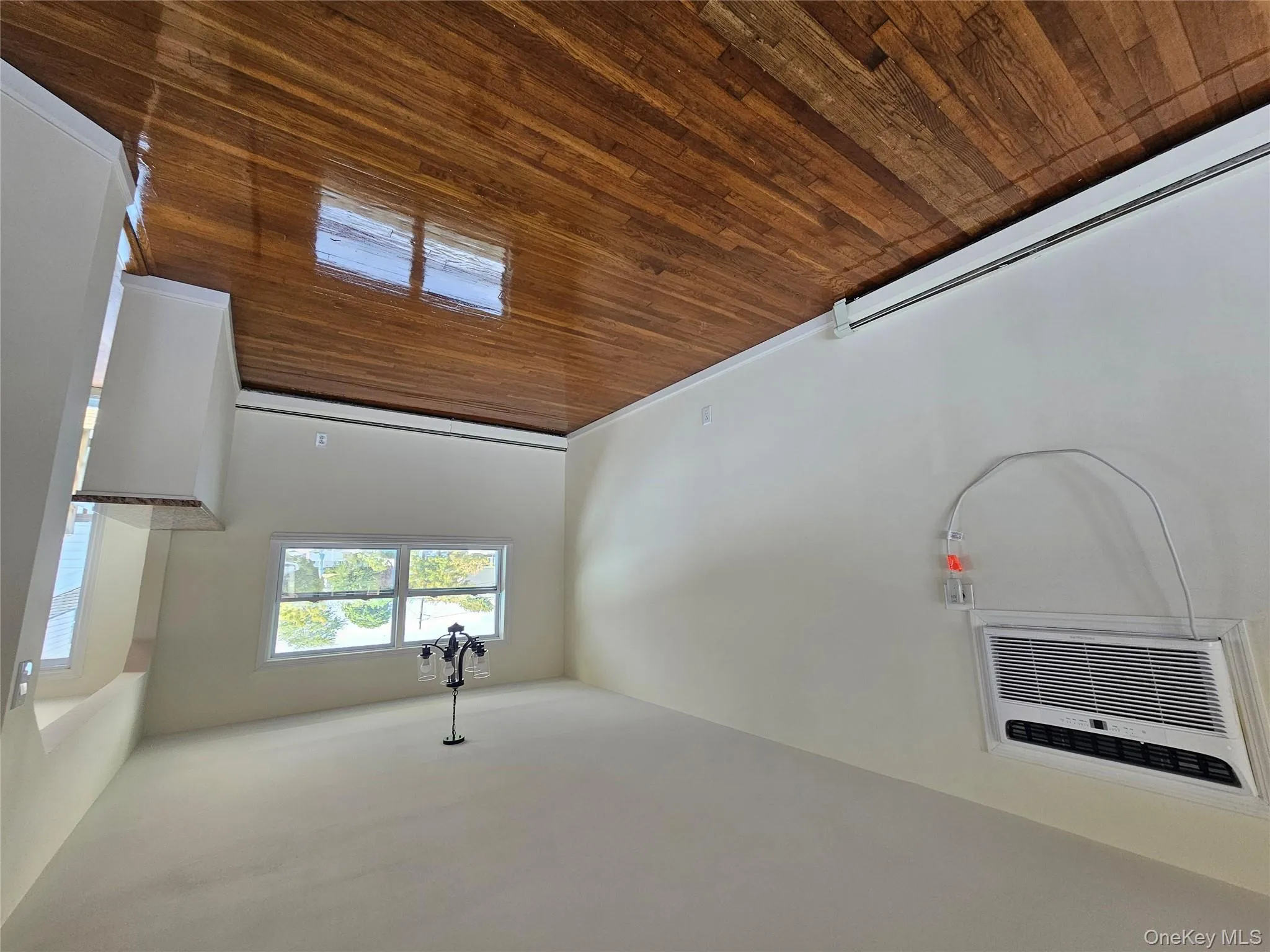 Unfurnished dining area with dark wood finished floors, a chandelier, a baseboard radiator, and an AC wall unit Unfurnished dining area with dark wood finished floors, a chandelier, a baseboard radiator, and an AC wall unit