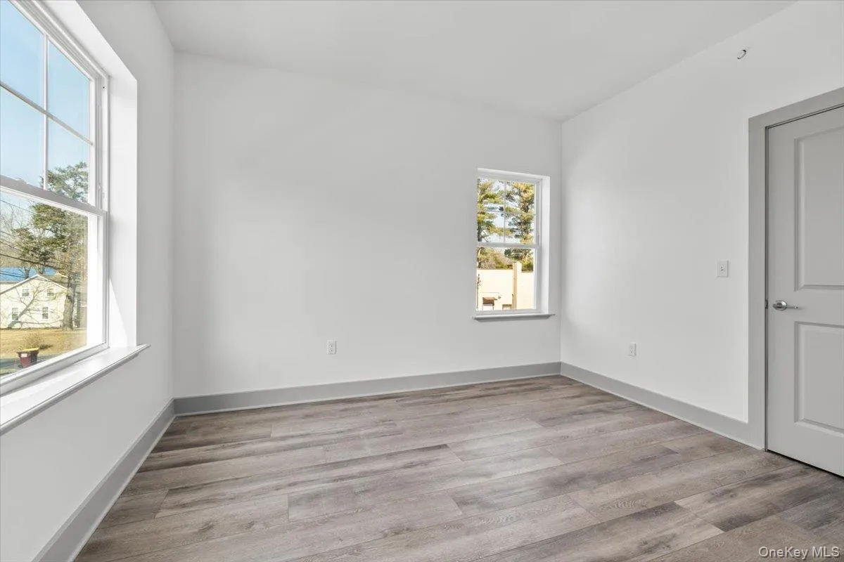 Unfurnished room with light wood-style floors and baseboards Unfurnished room with light wood-style floors and baseboards