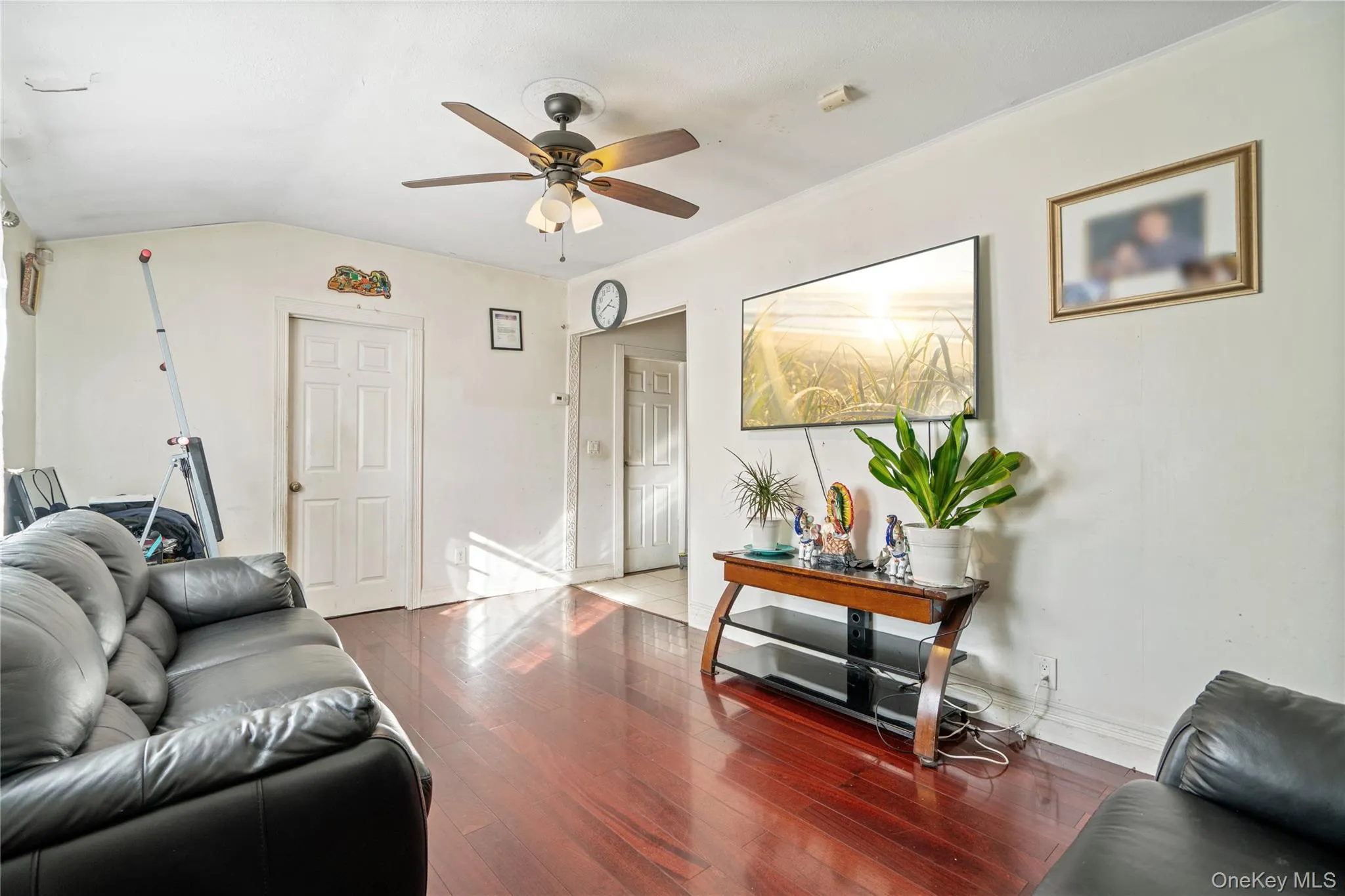 Living area featuring wood finished floors, lofted ceiling, and a ceiling fan Living area featuring wood finished floors, lofted ceiling, and a ceiling fan