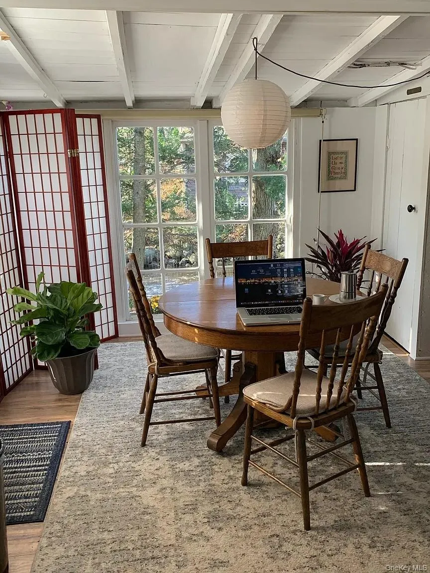 Dining area featuring light wood-style floors and beamed ceiling Dining area featuring light wood-style floors and beamed ceiling