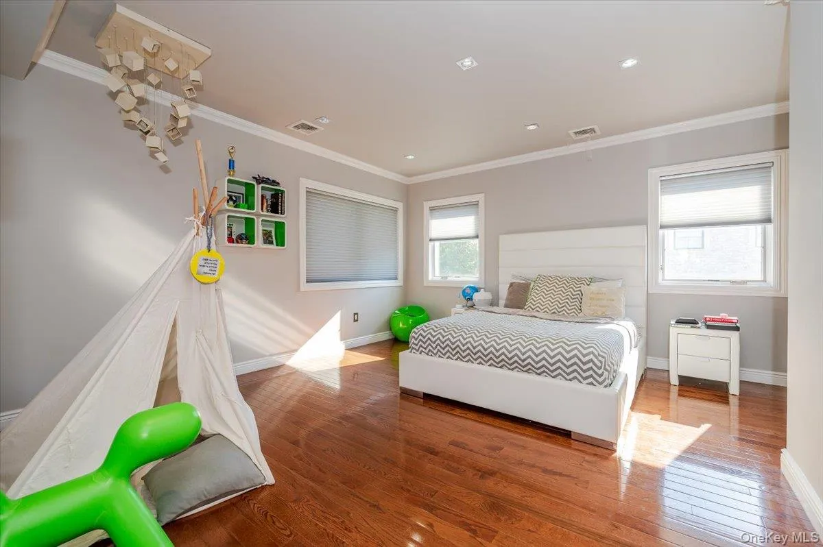 Bedroom with ornamental molding, light wood finished floors, and recessed lighting Bedroom with ornamental molding, light wood finished floors, and recessed lighting
