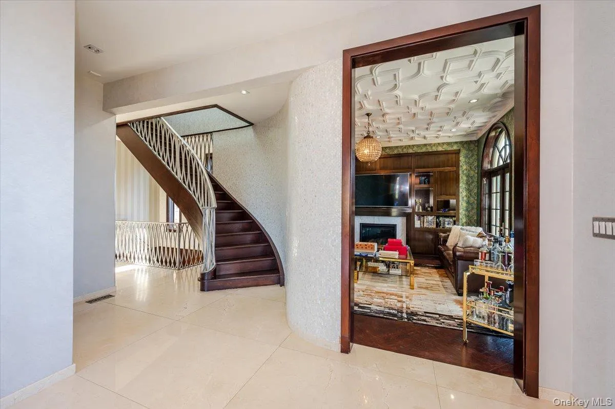 Stairway with tile patterned flooring and a glass covered fireplace Stairway with tile patterned flooring and a glass covered fireplace