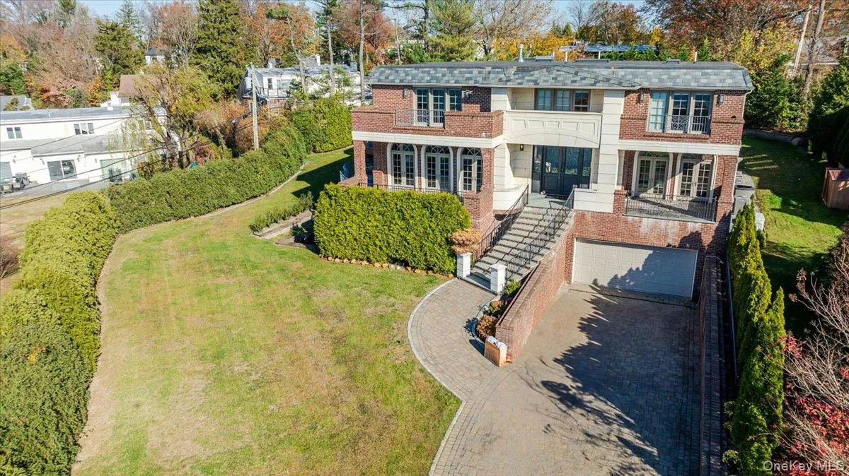 View of front facade featuring brick siding, french doors, driveway, a front lawn, and a garage View of front facade featuring brick siding, french doors, driveway, a front lawn, and a garage