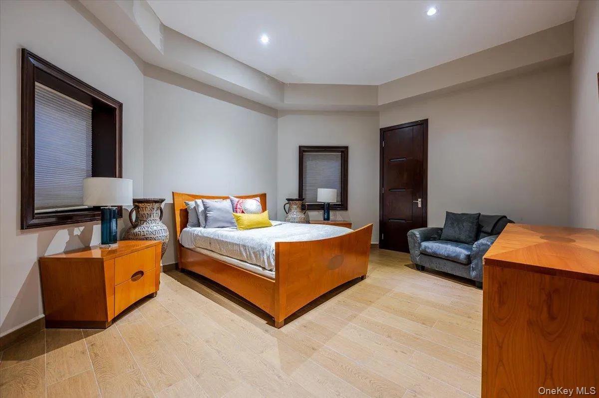 Bedroom featuring light wood finished floors and a tray ceiling Bedroom featuring light wood finished floors and a tray ceiling