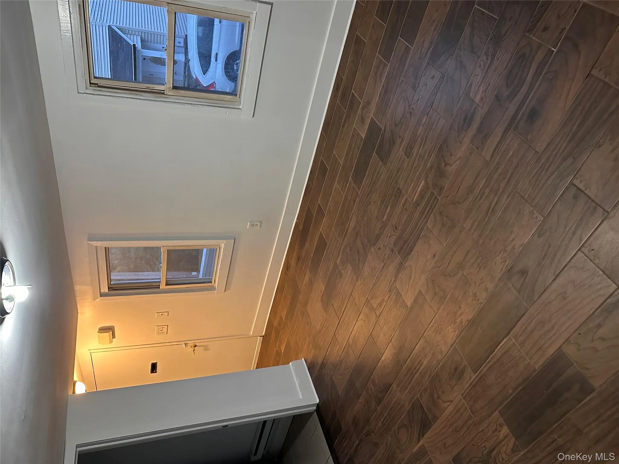 Unfurnished room featuring dark wood-style flooring and a baseboard radiator Unfurnished room featuring dark wood-style flooring and a baseboard radiator
