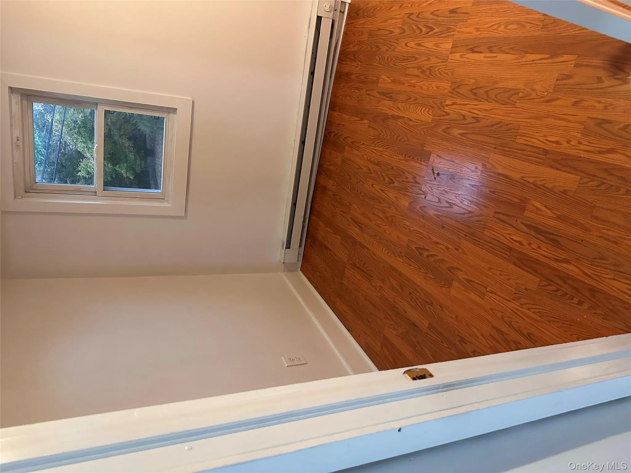 Unfurnished room featuring wood finished floors and a baseboard heating unit Unfurnished room featuring wood finished floors and a baseboard heating unit