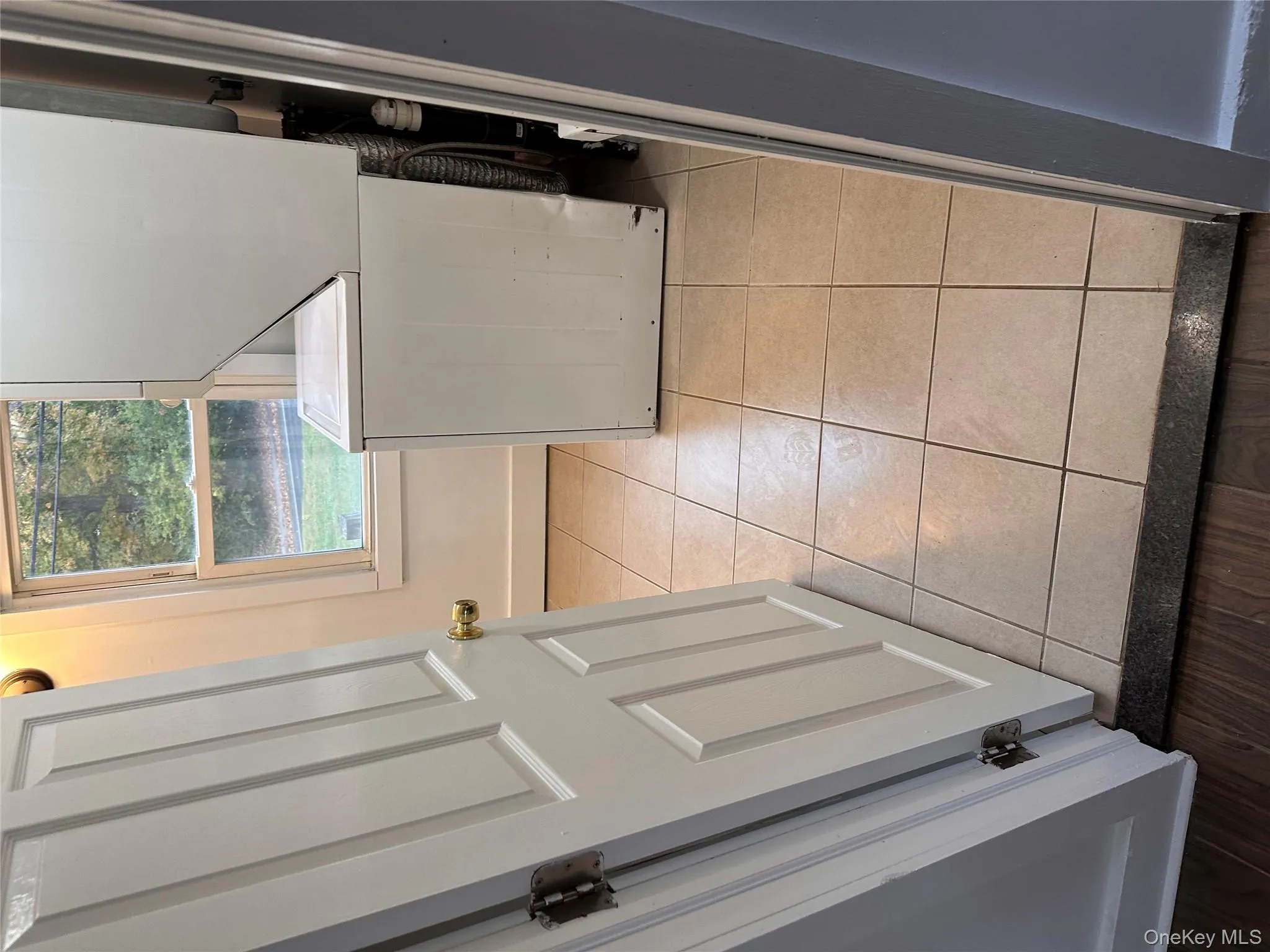 Laundry room featuring light tile patterned flooring and stacked washing machine and dryer Laundry room featuring light tile patterned flooring and stacked washing machine and dryer