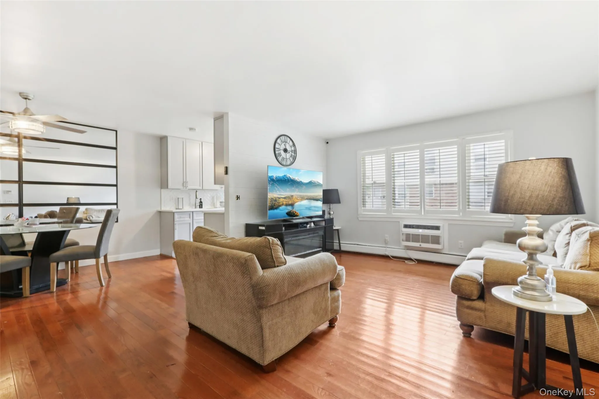 Living room featuring wood finished floors and a newer wall mounted AC unit Living room featuring wood finished floors and a newer wall mounted AC unit
